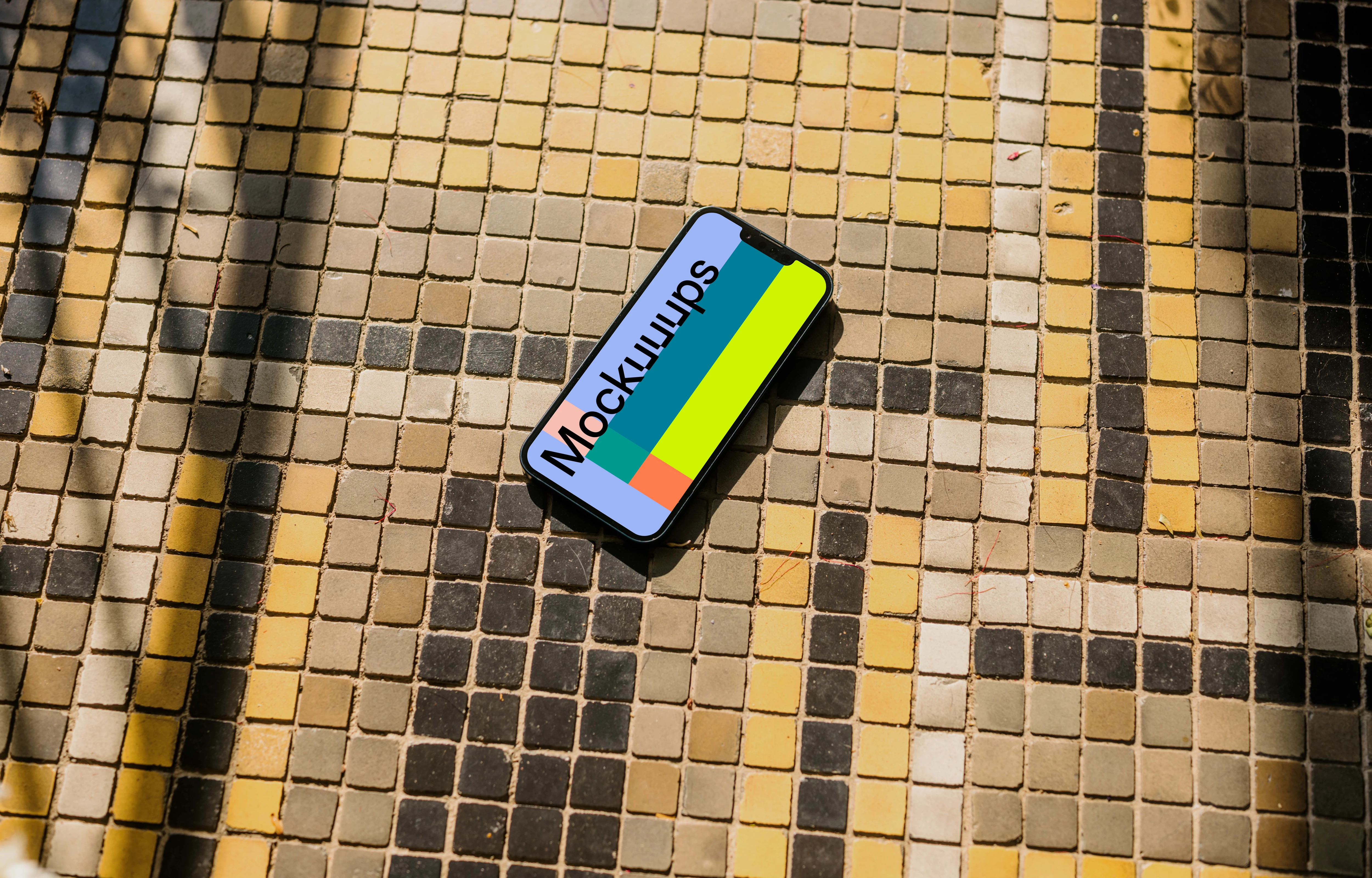 iPhone 13 mockup on a colorful garden paving