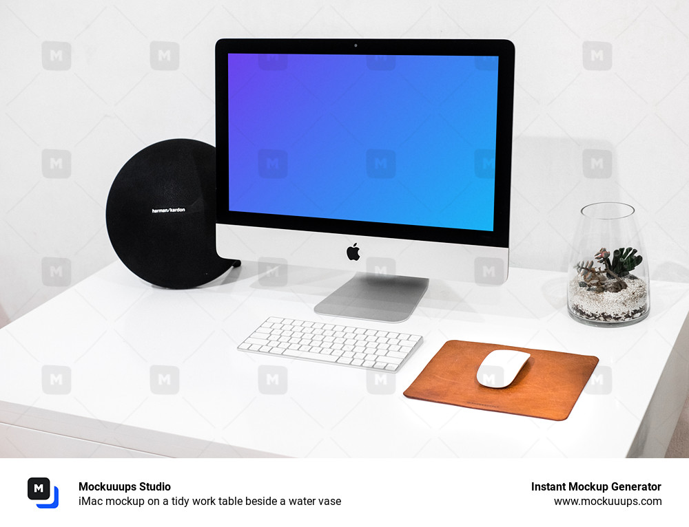 iMac mockup on a tidy work table beside a water vase