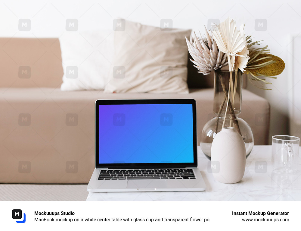 MacBook mockup on a white center table with glass cup and transparent flower po
