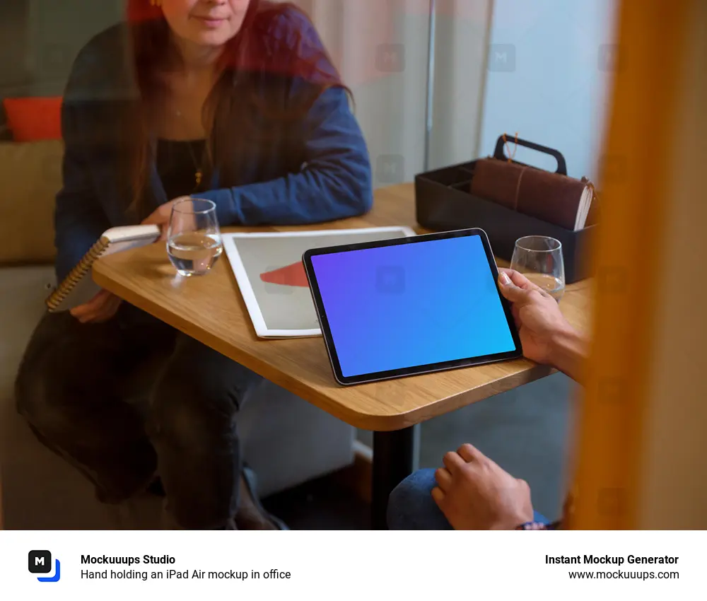 Hand holding an iPad Air mockup in office