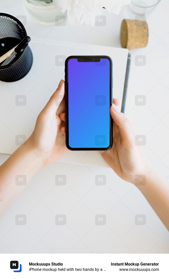 iPhone mockup held with two hands by a user above a white table