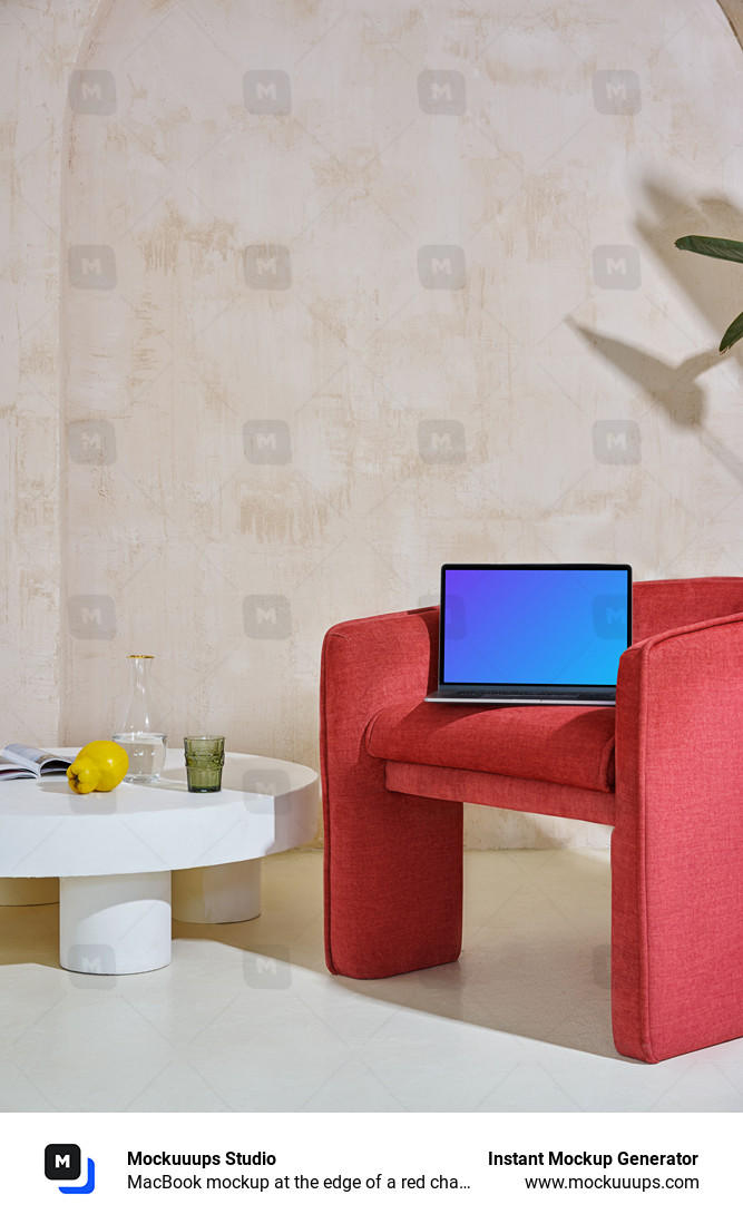 MacBook mockup at the edge of a red chair with a center table at the side