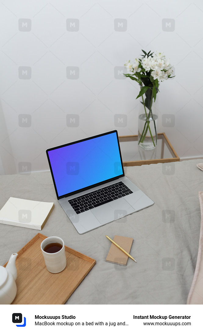MacBook mockup on a bed with a jug and ceramic on a wooden tray and a notebook at the side