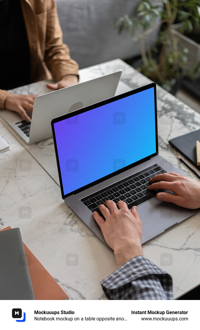 Notebook mockup on a table opposite another MacBook Pro