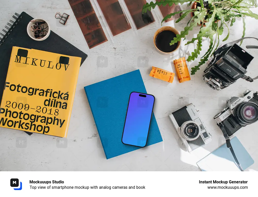 Top view of smartphone mockup with analog cameras and book