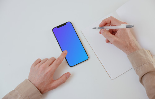 iPhone mockup on a white table with a textbook at the side
