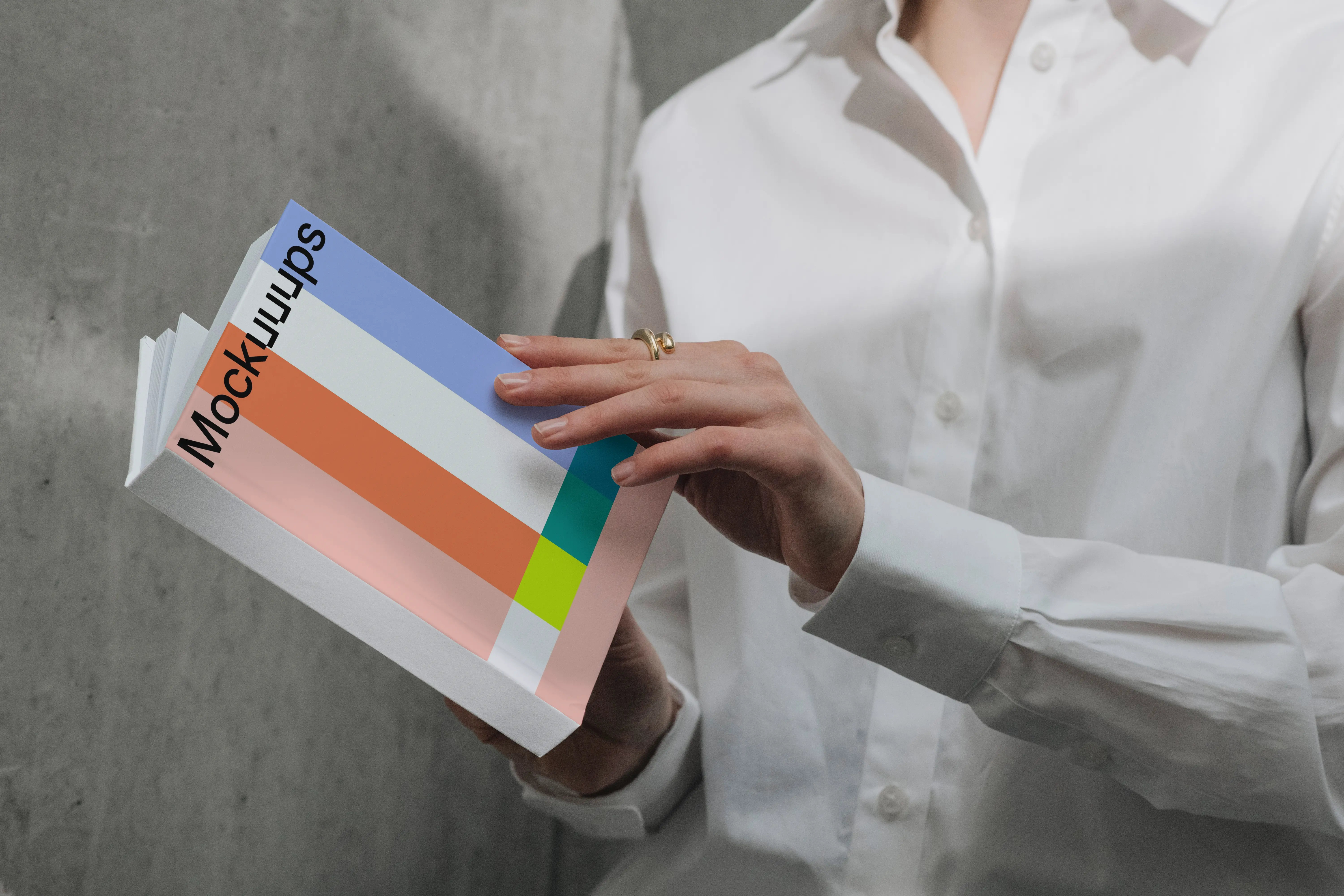 A-format book mockup held by person in white shirt