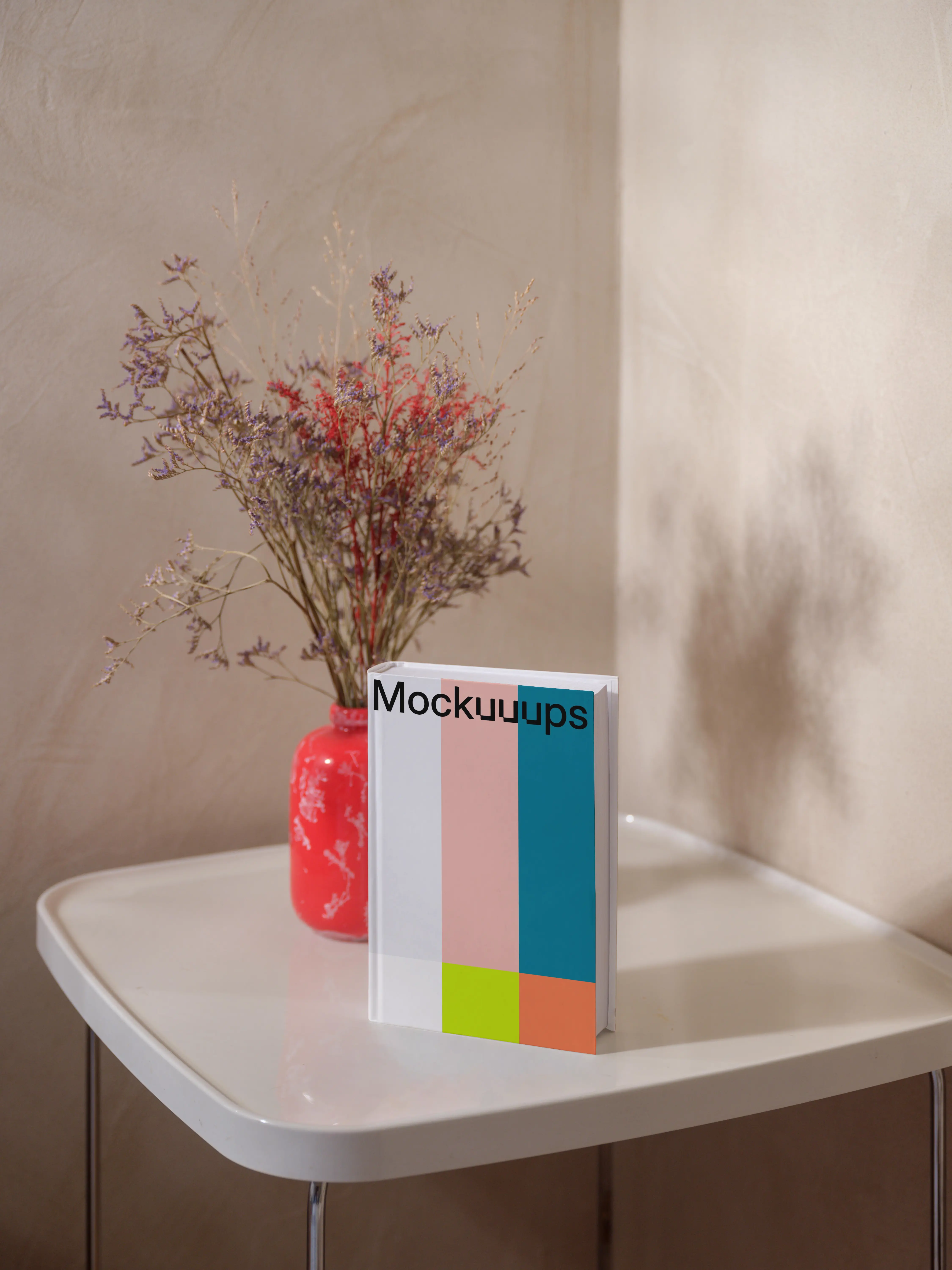 B-format book mockup on a white table with a red vase