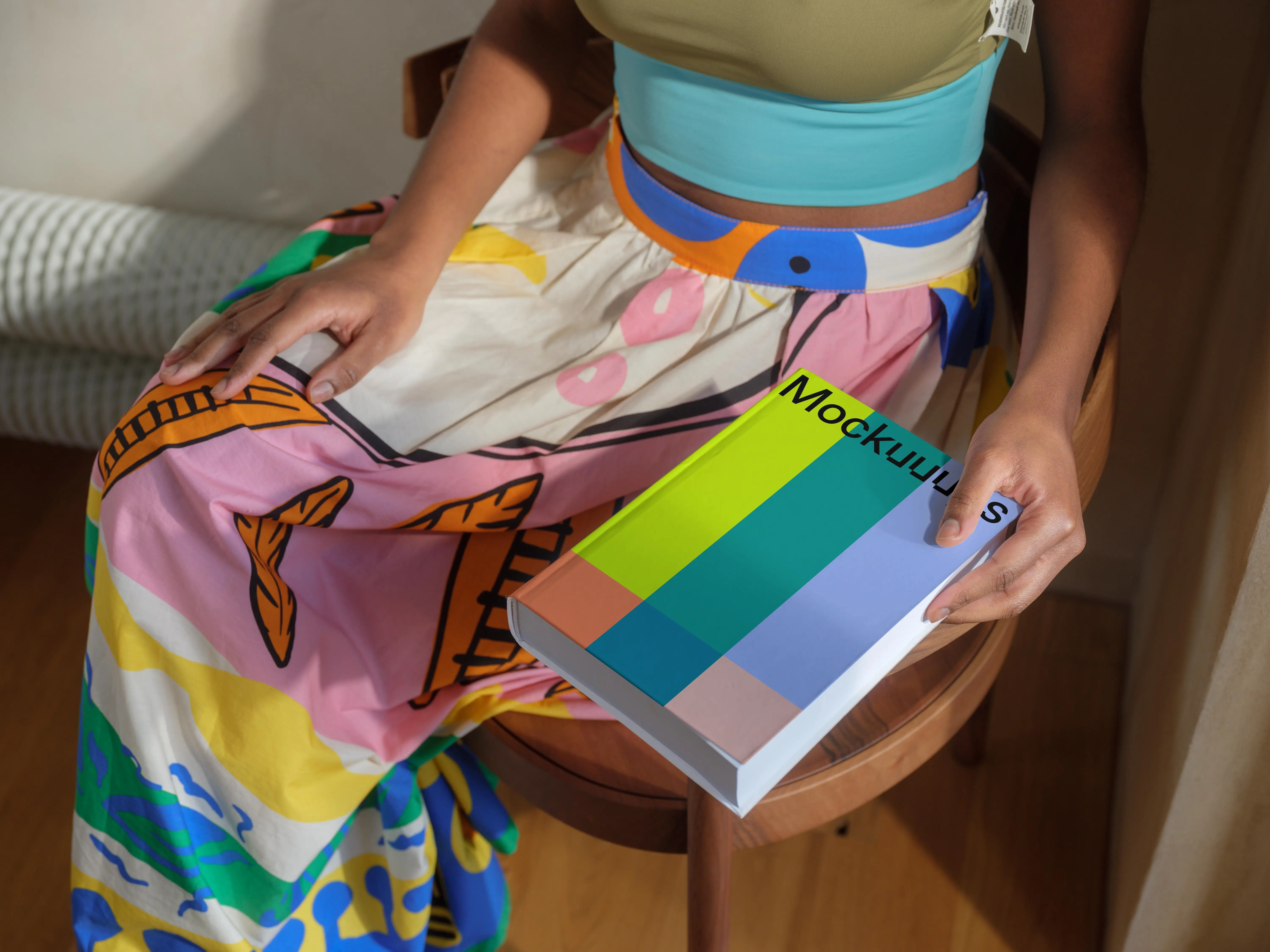 Book mockup held by a person in colorful attire