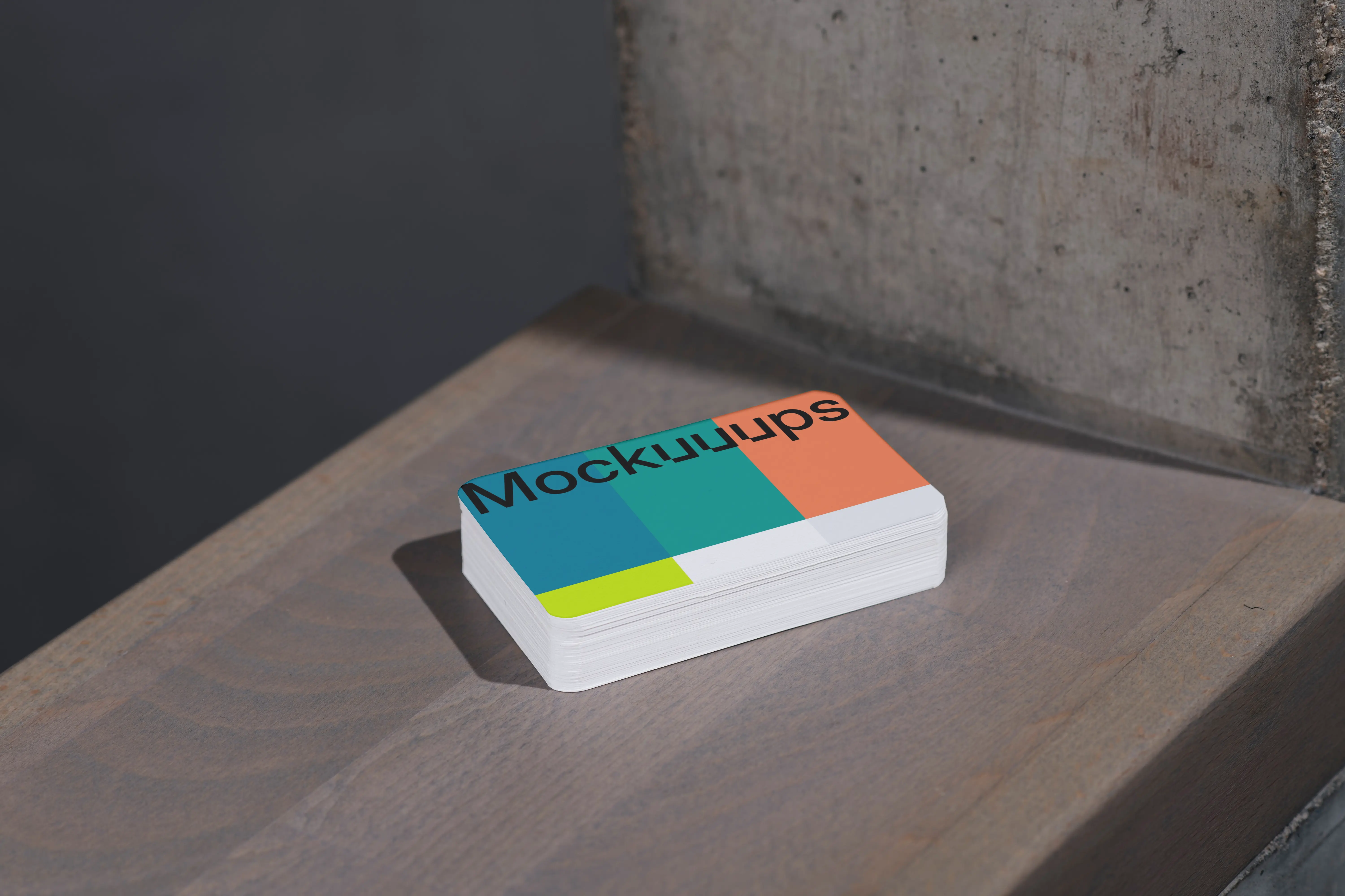Business card mockup on wooden surface near concrete wall