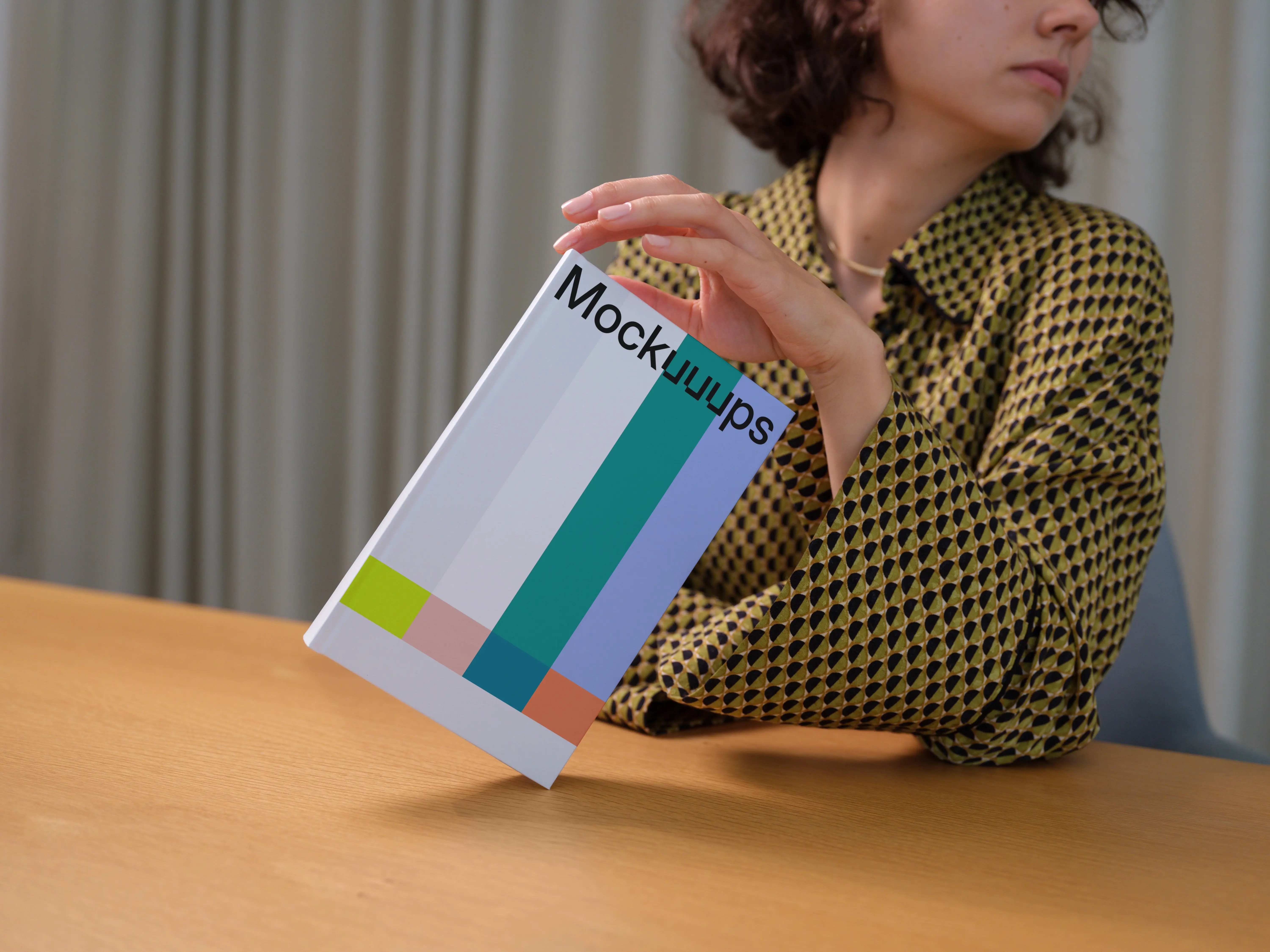 C-format book mockup held in a modern setting