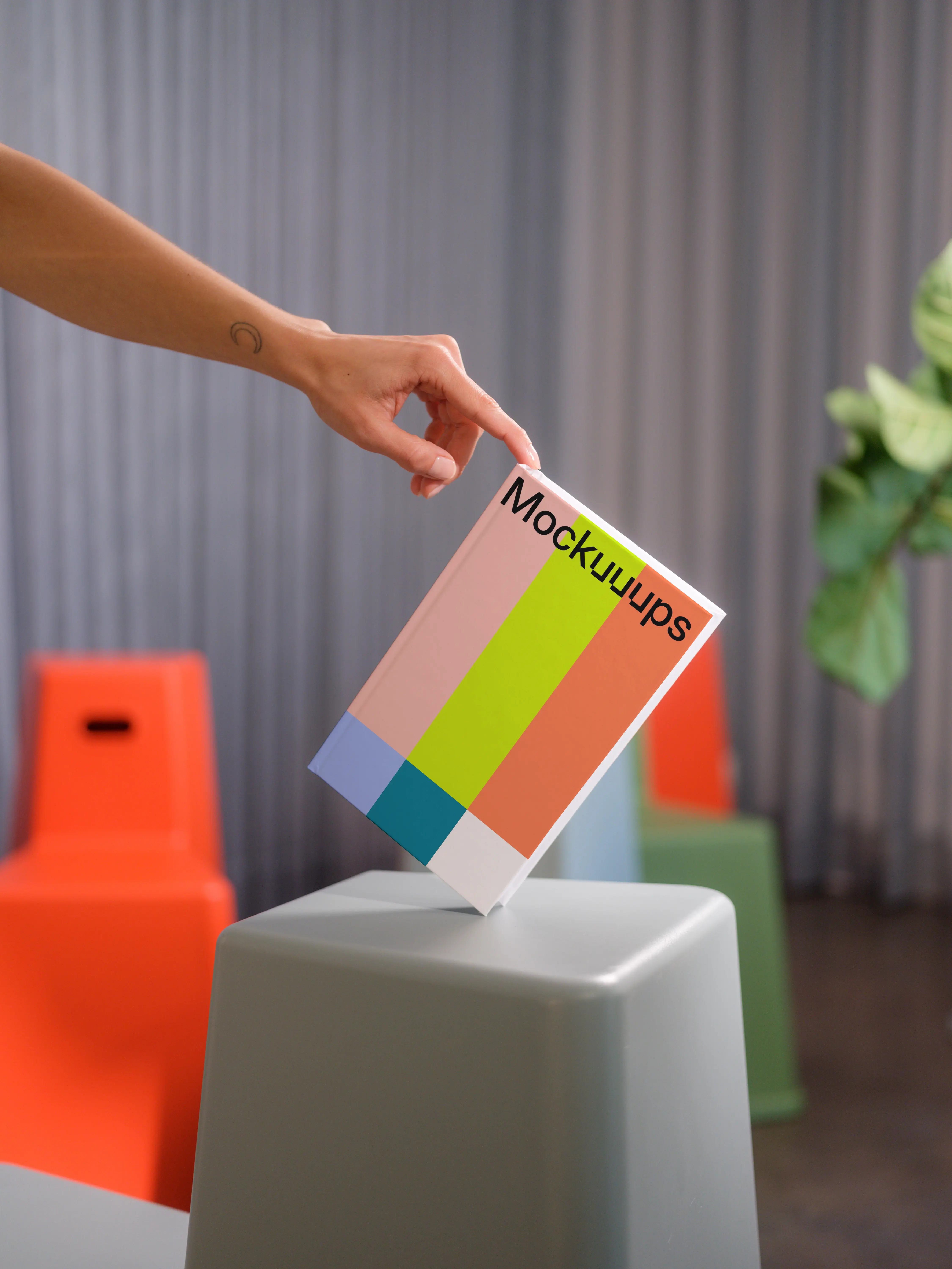 C-format book mockup held over modern stools