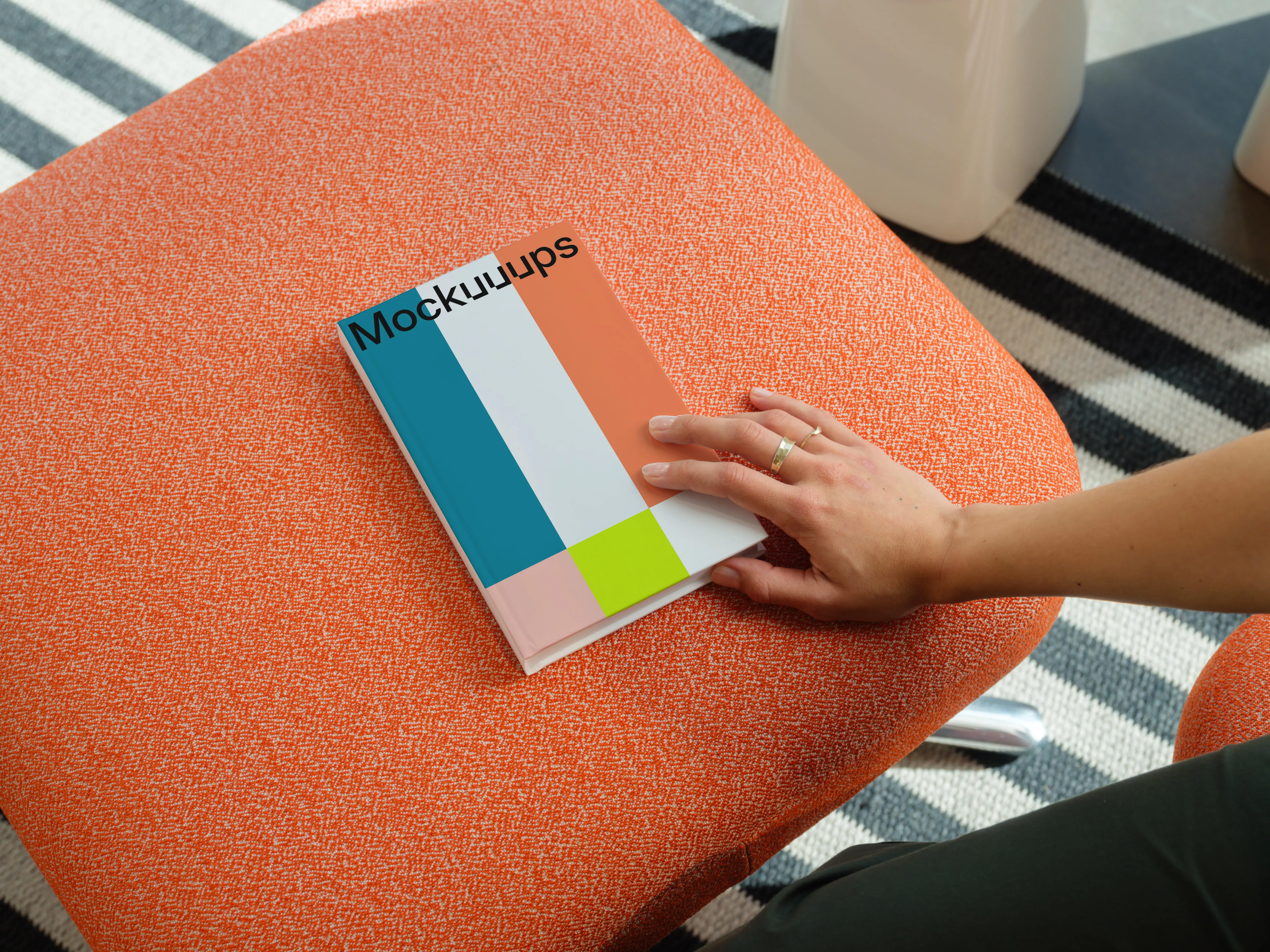 C-format book mockup on an orange ottoman