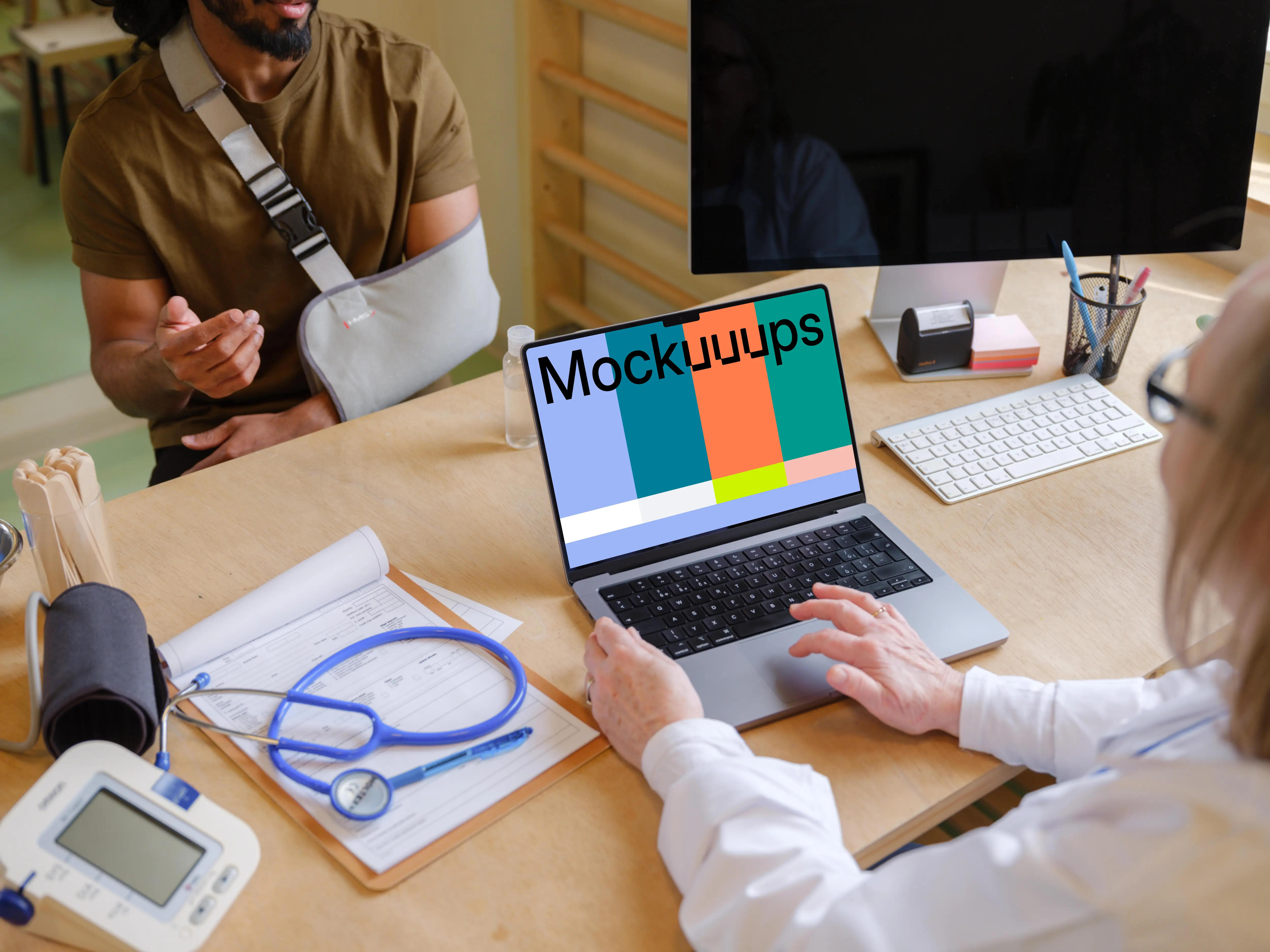 Doctor typing on laptop while talking with the patient