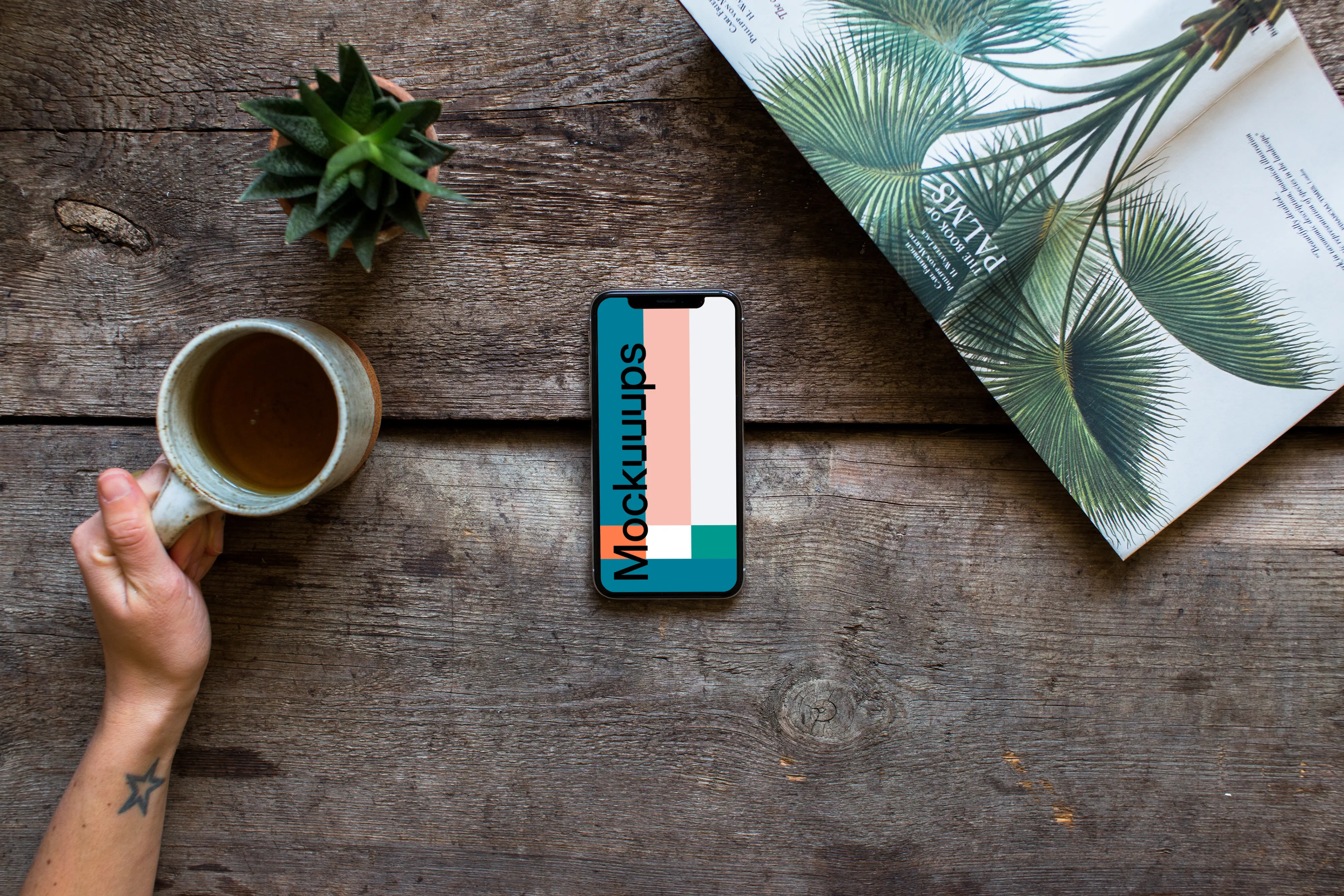 Drinking tea over the iPhone XS mockup and plants