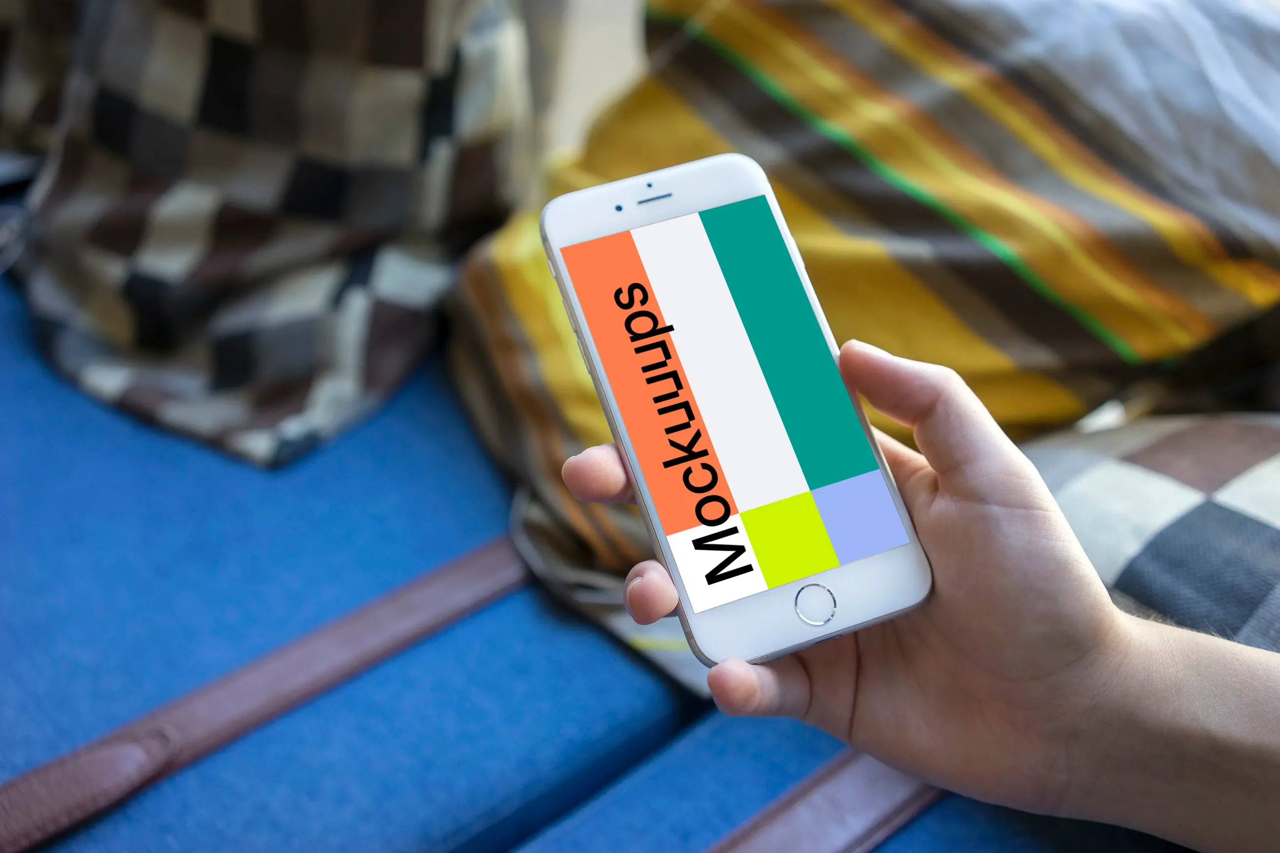 Holding iPhone 6 mockup on a Sofa with Pillows