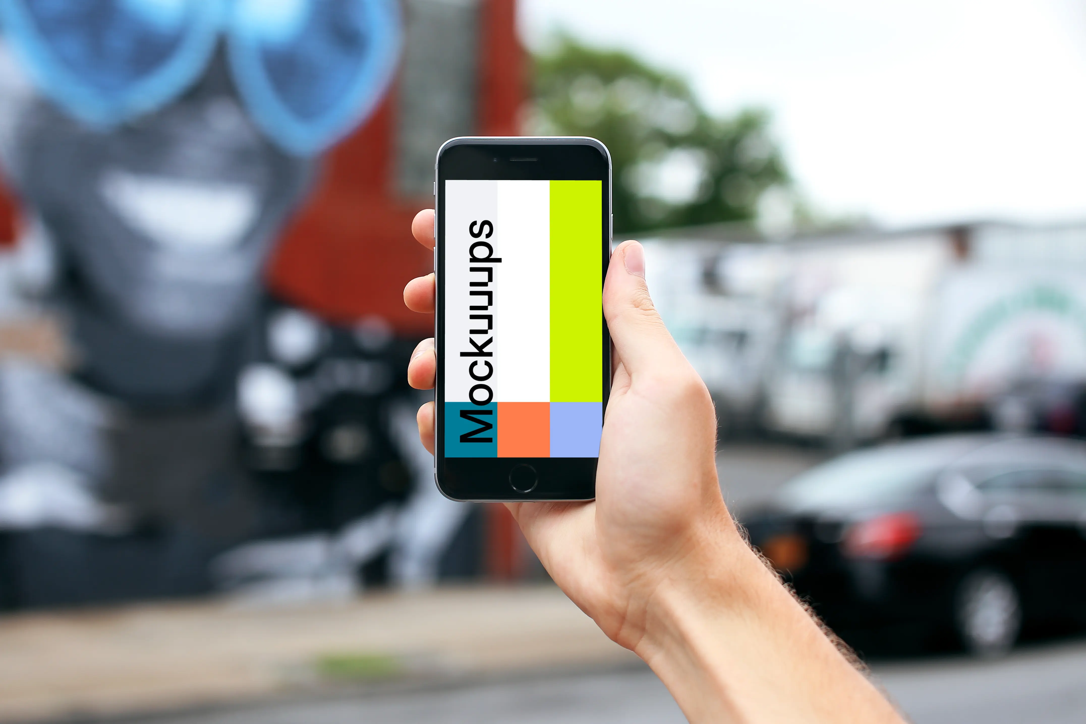 Holding iPhone 6s mockup in front Street Art