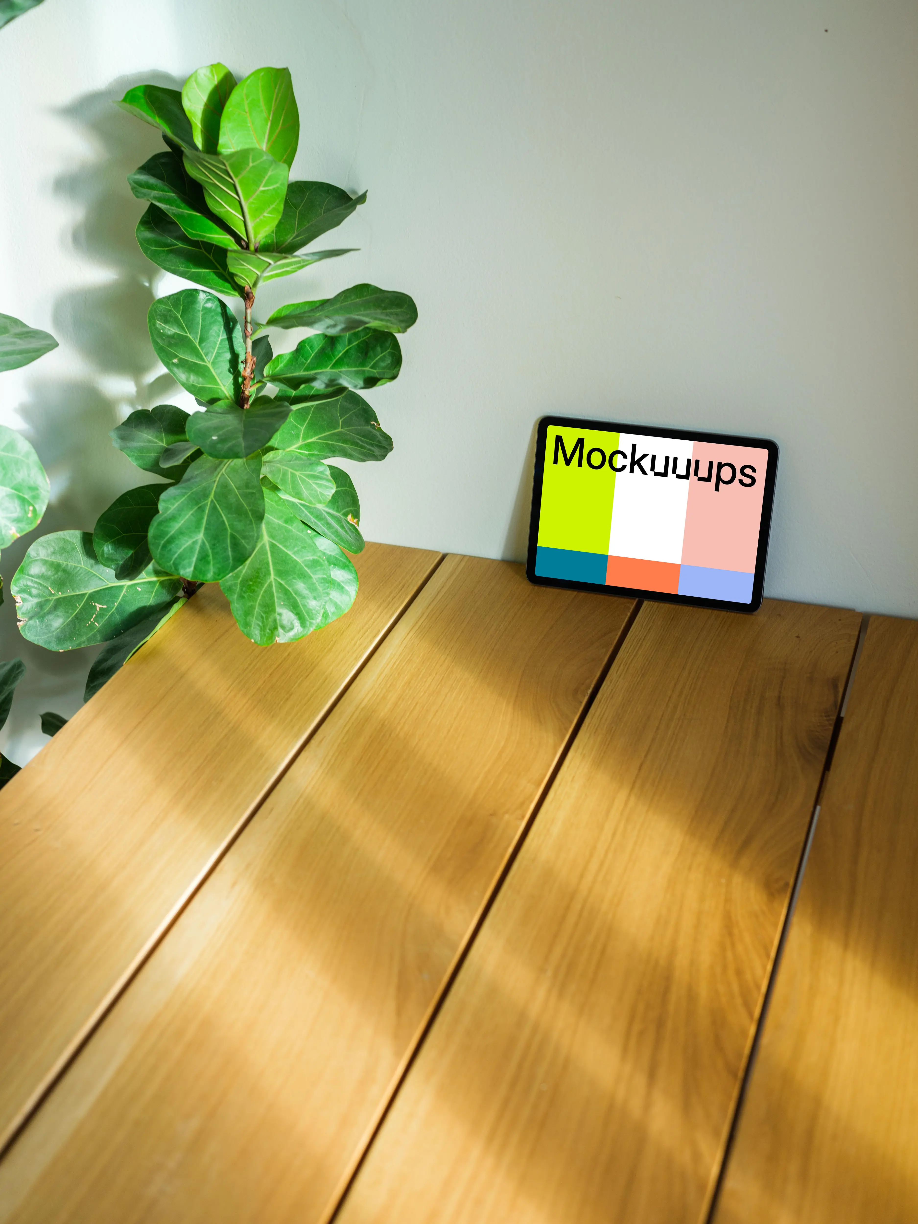 iPad Air mockup leaning on a wall beside a plant