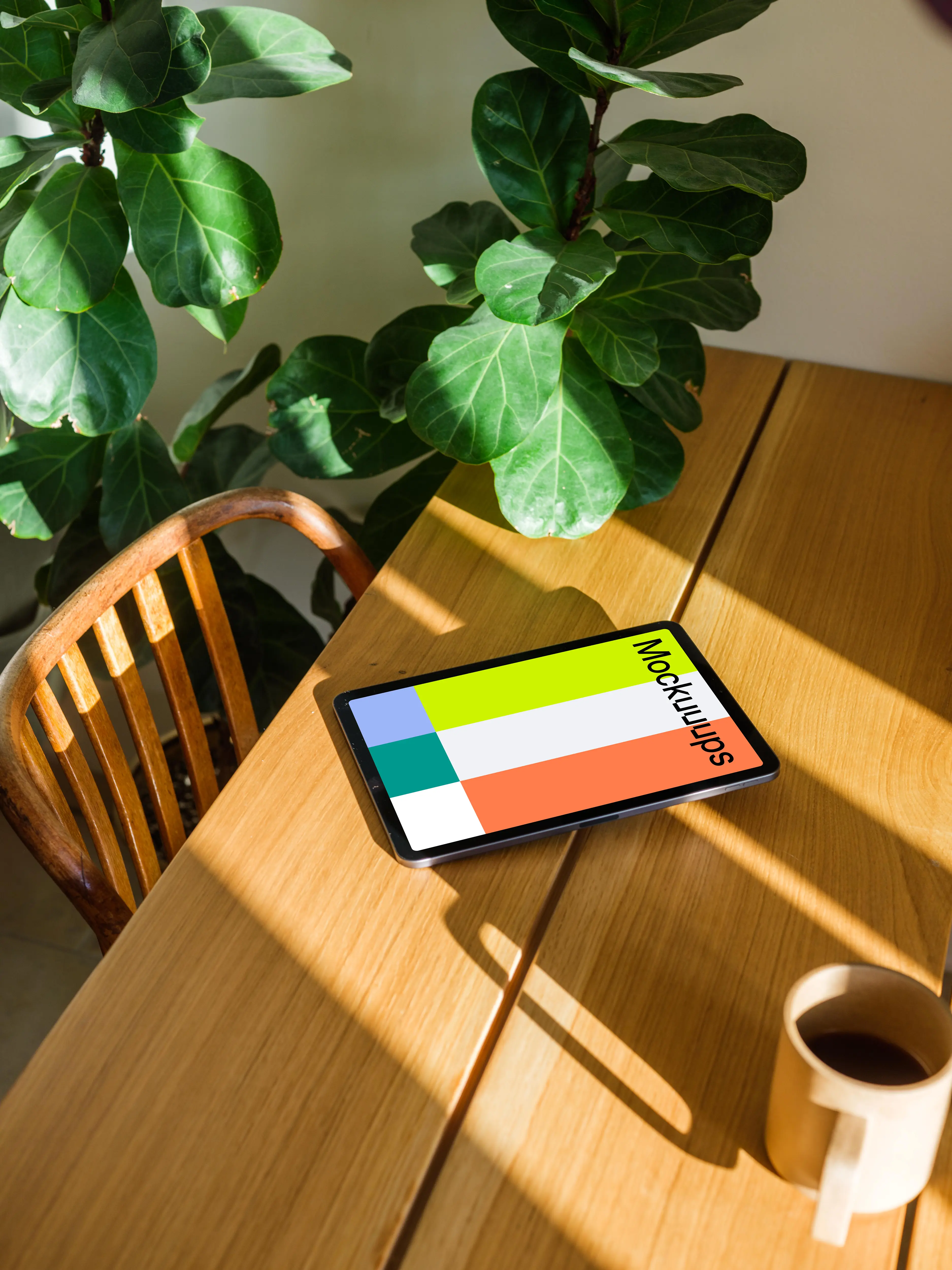 iPad Air mockup on a wooden table beside a plant