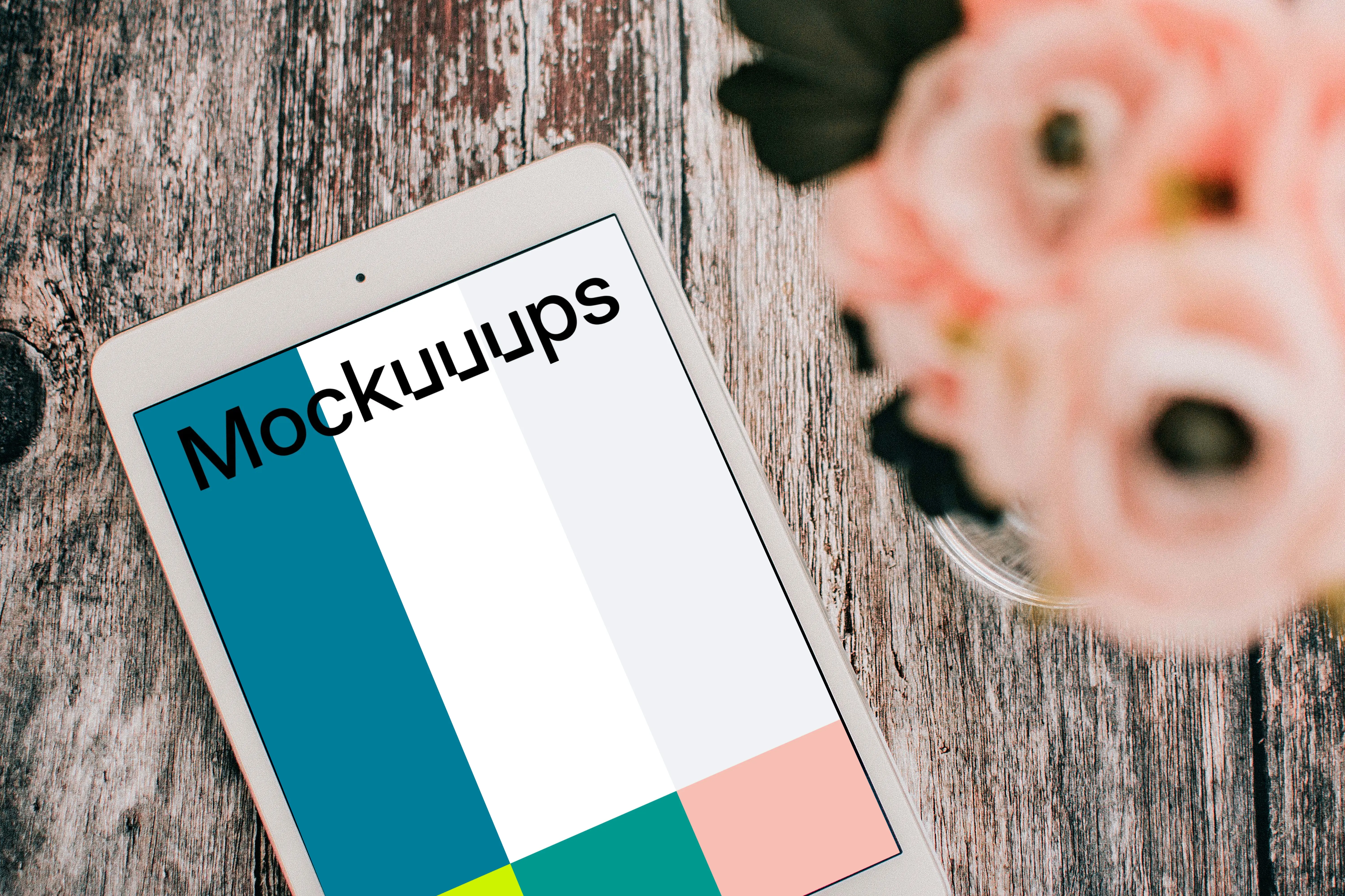 iPad Mini mockup a brown table beside a vase of roses