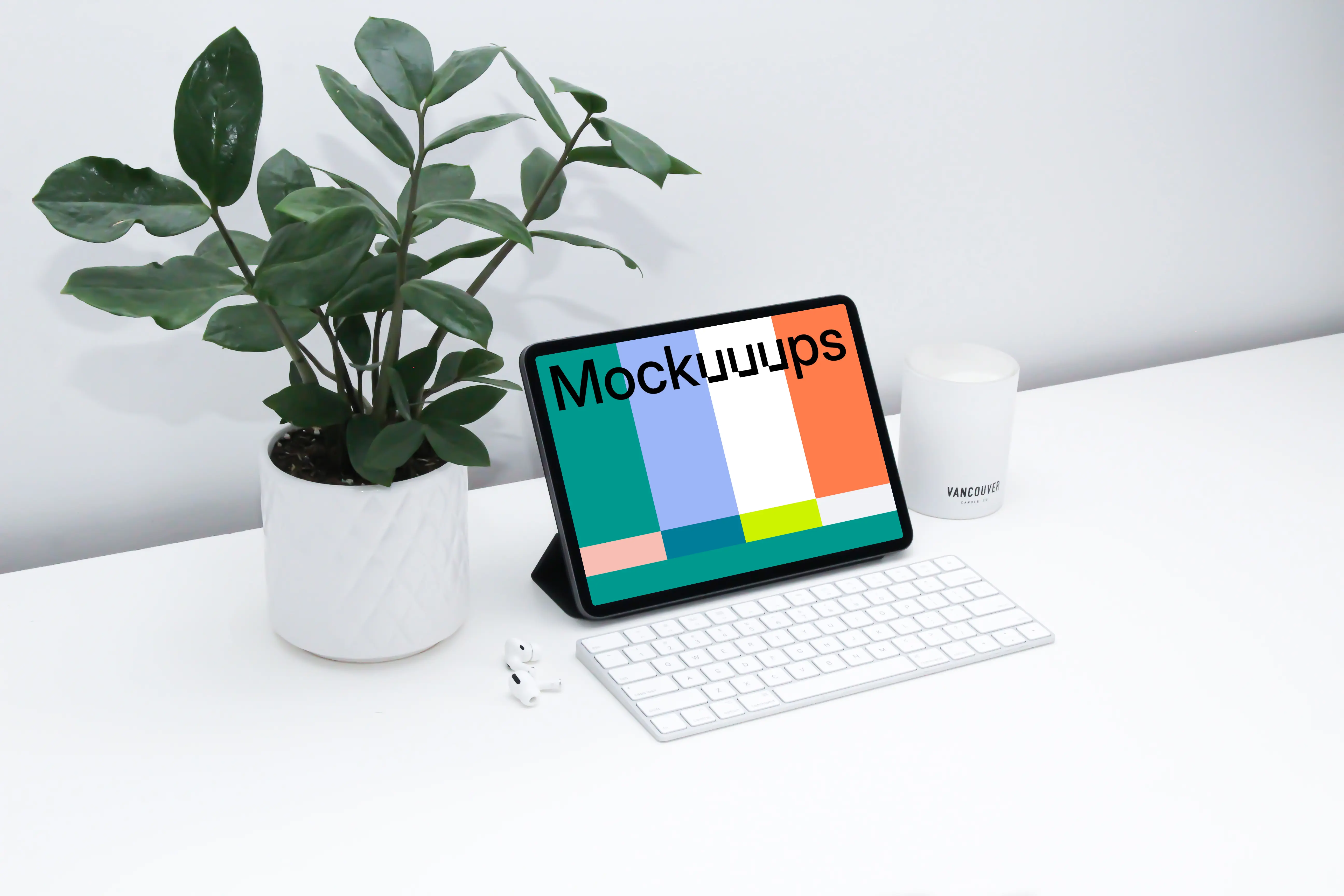 iPad mockup on a white table beside Airpods Pro