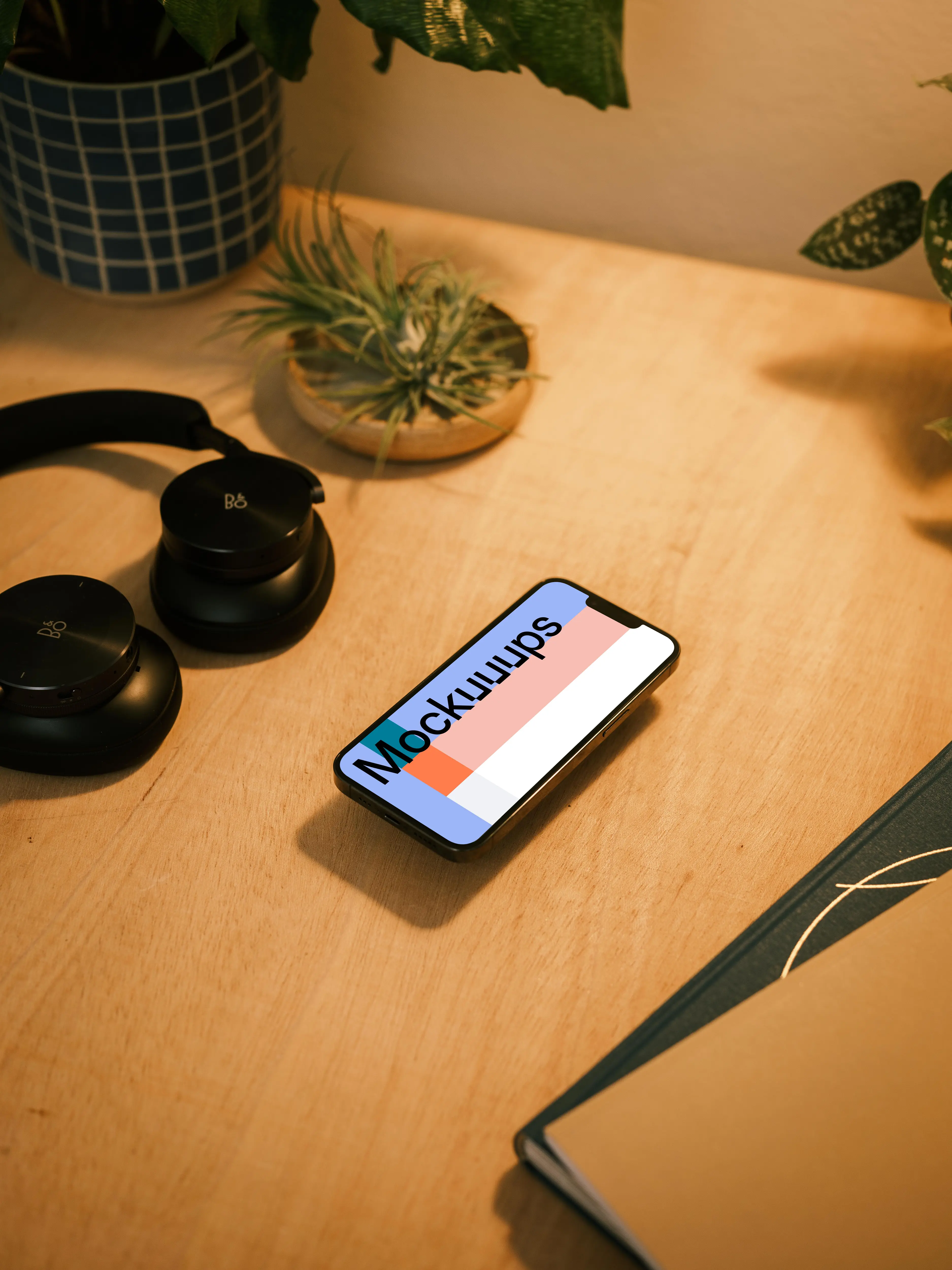 iPhone 13 Pro mockup with a pair of headphones at the side