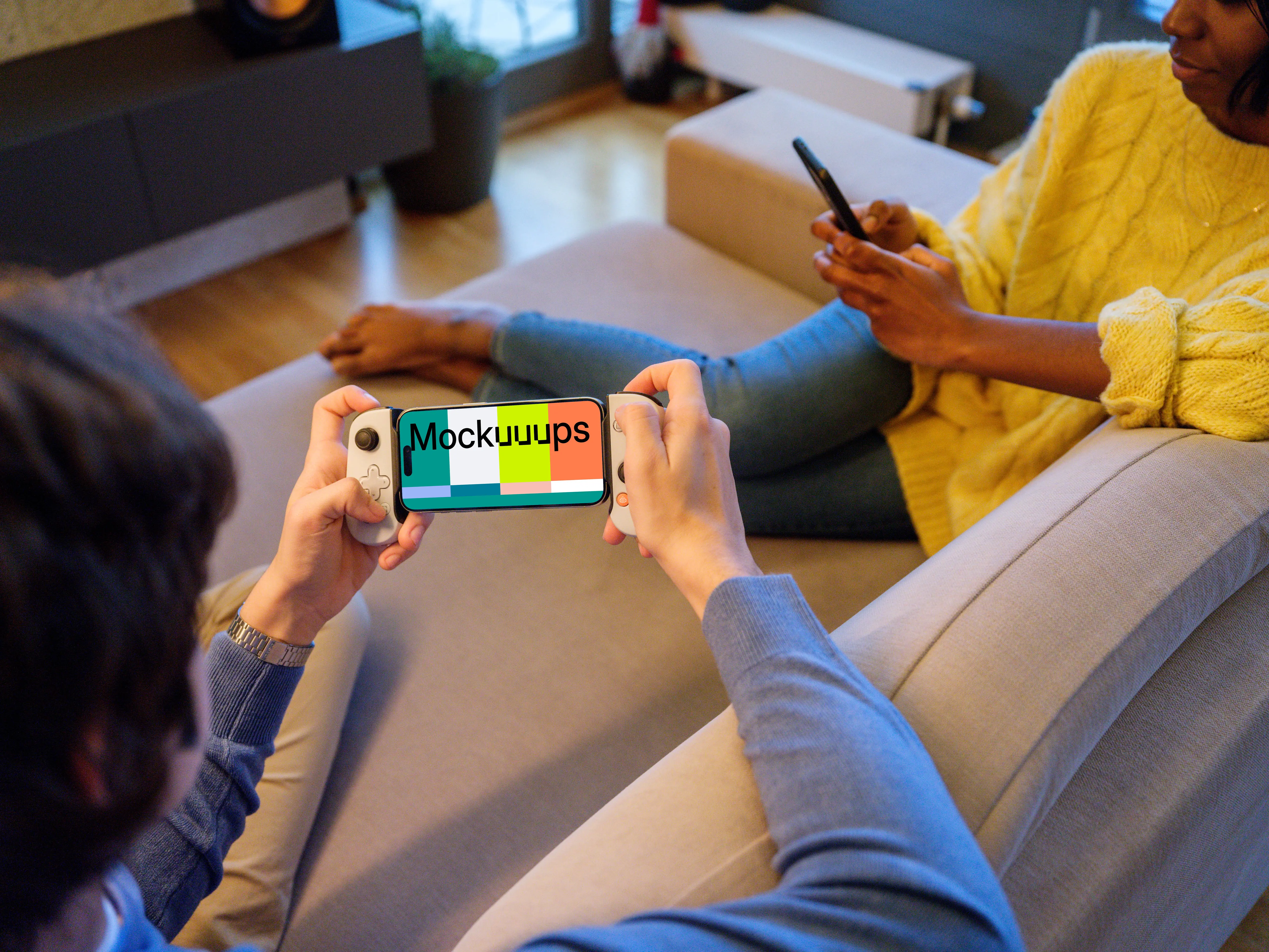 iPhone 15 Pro mockup in a gamer's hand on a couch