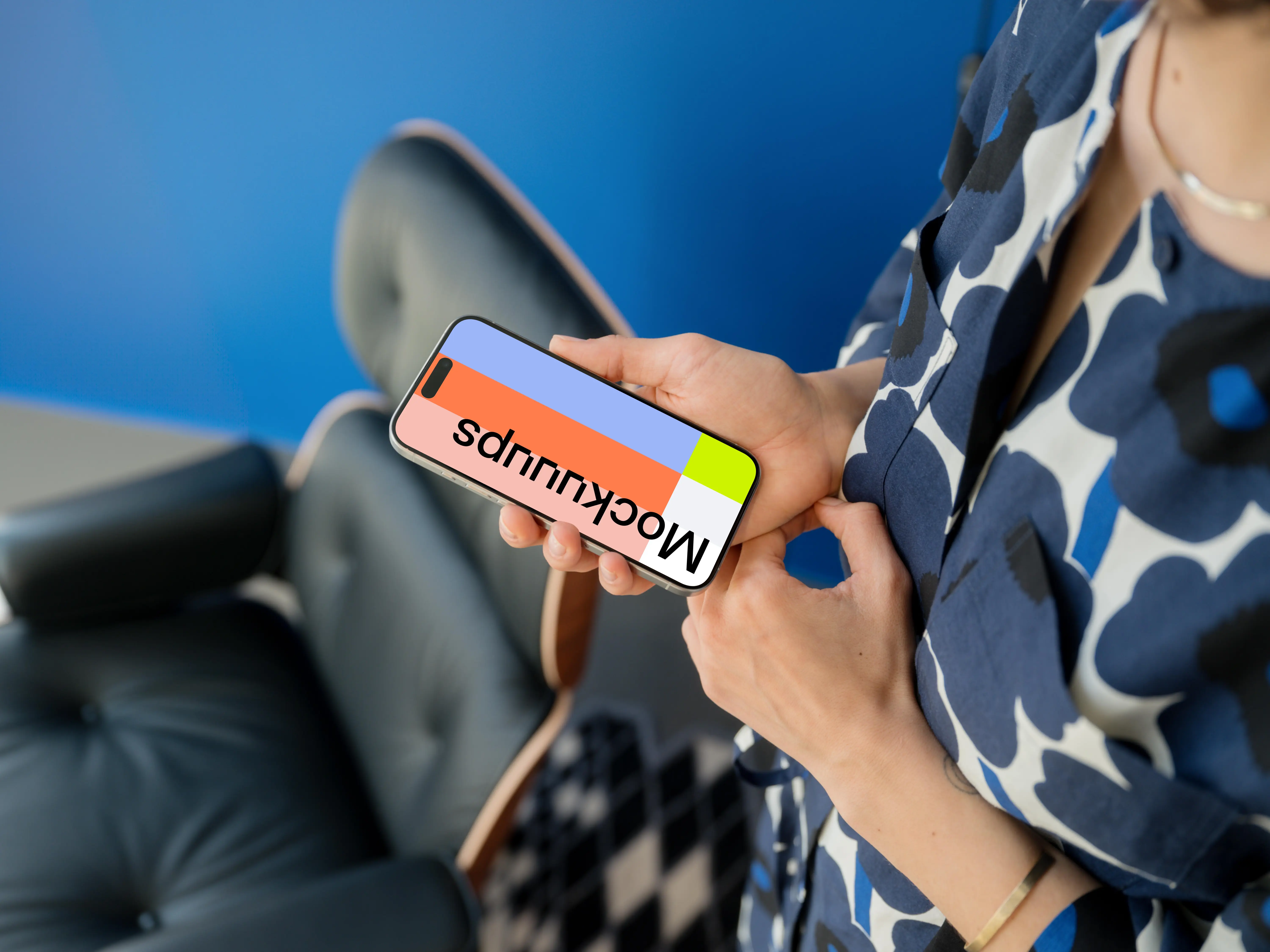 iPhone 15 Pro mockup in woman's hand against blue background