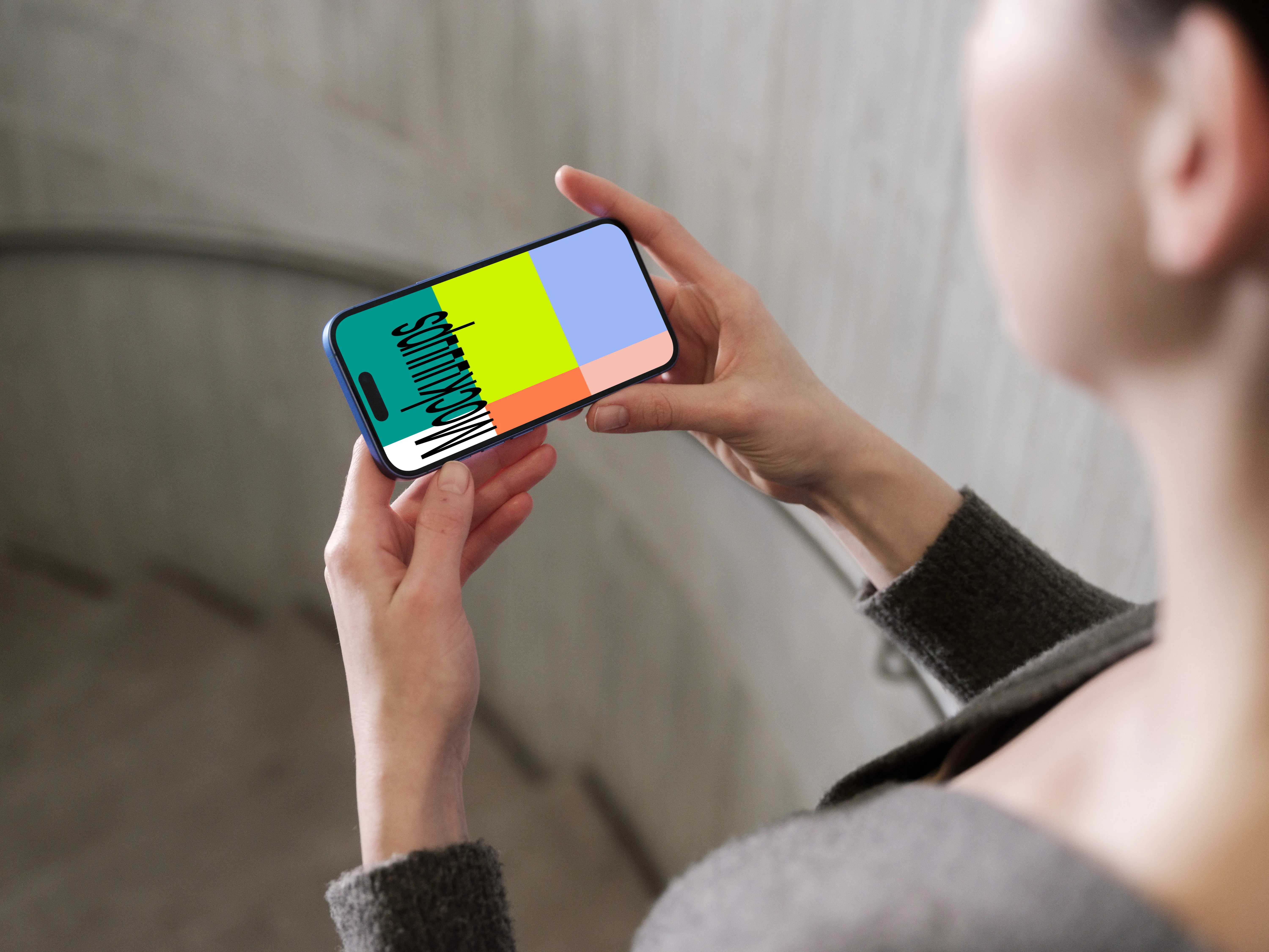 iPhone 16 mockup in a hand against concrete backdrop