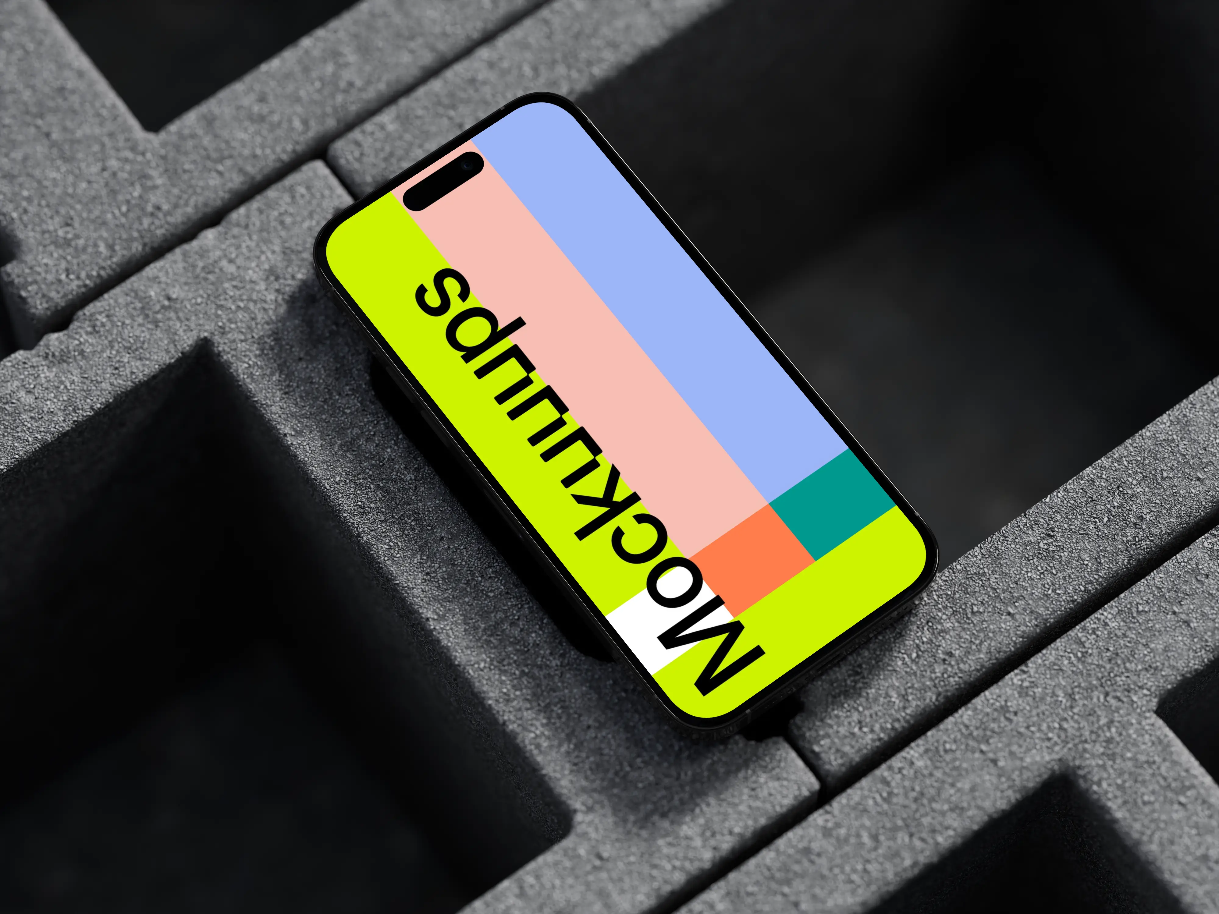 iPhone 16 mockup laying on concrete blocks