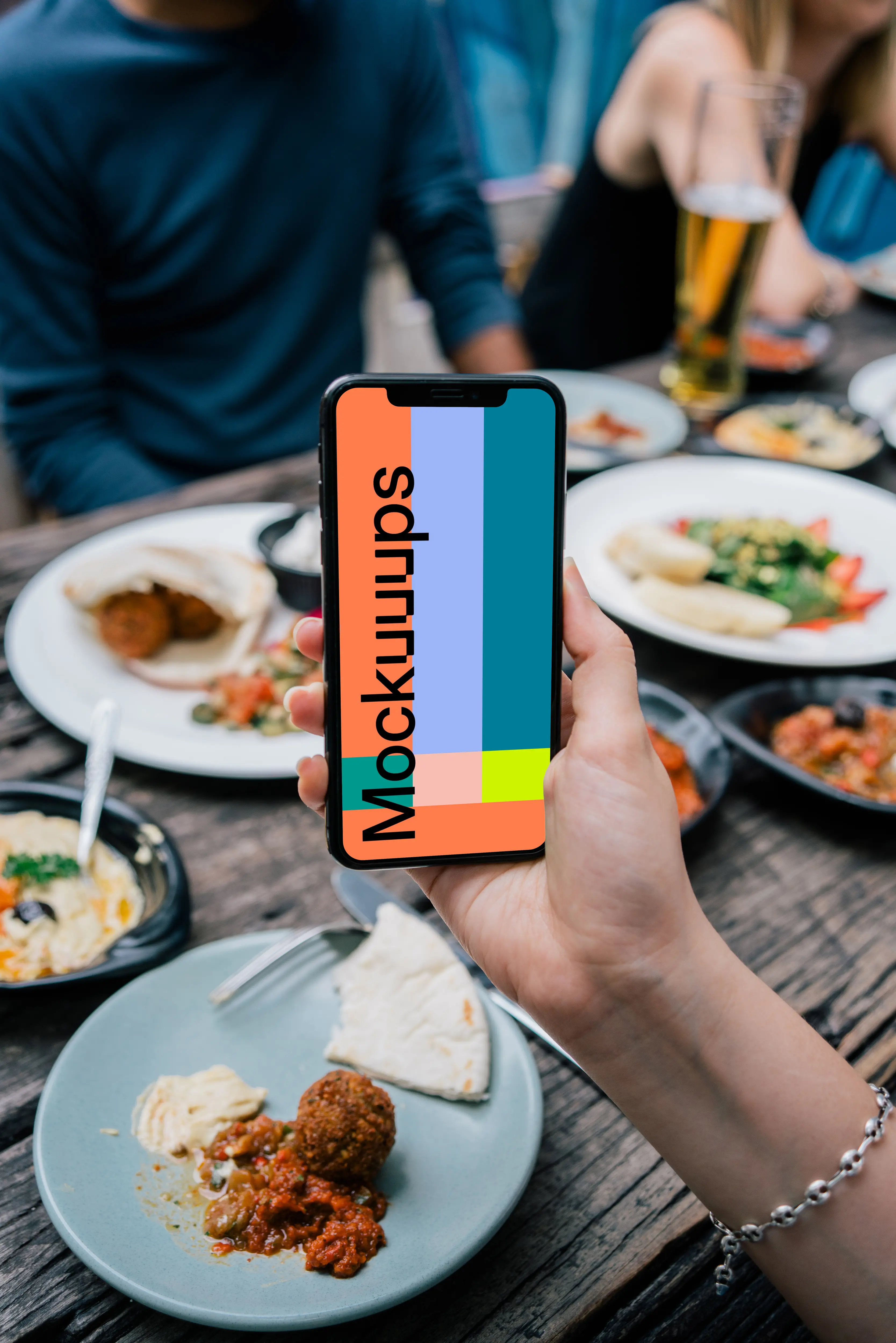 iPhone mockup held at lunch table