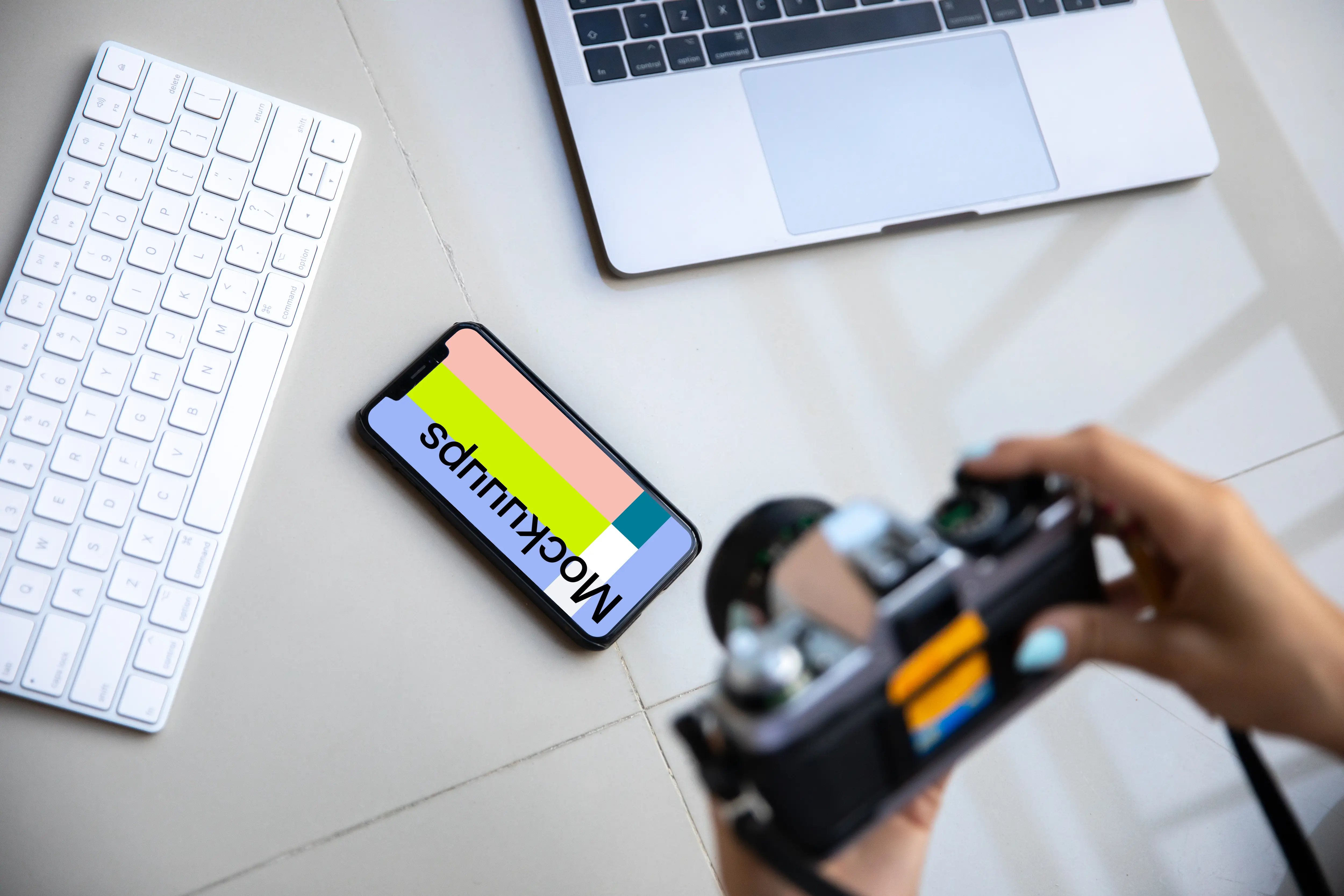 iPhone mockup on a table with a Macbook at the side