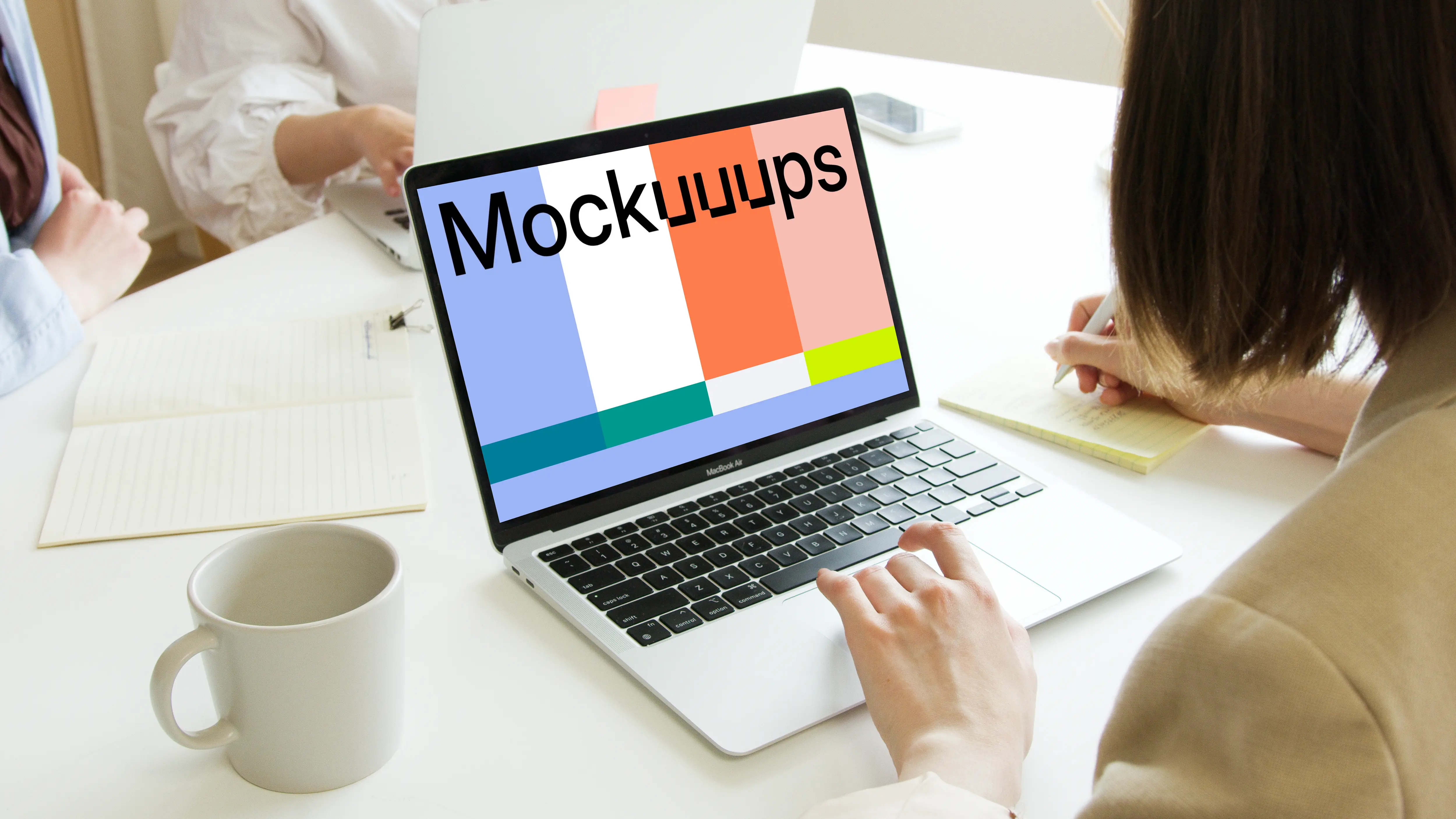 Lady using a MacBook Pro mockup and writing in a notepad