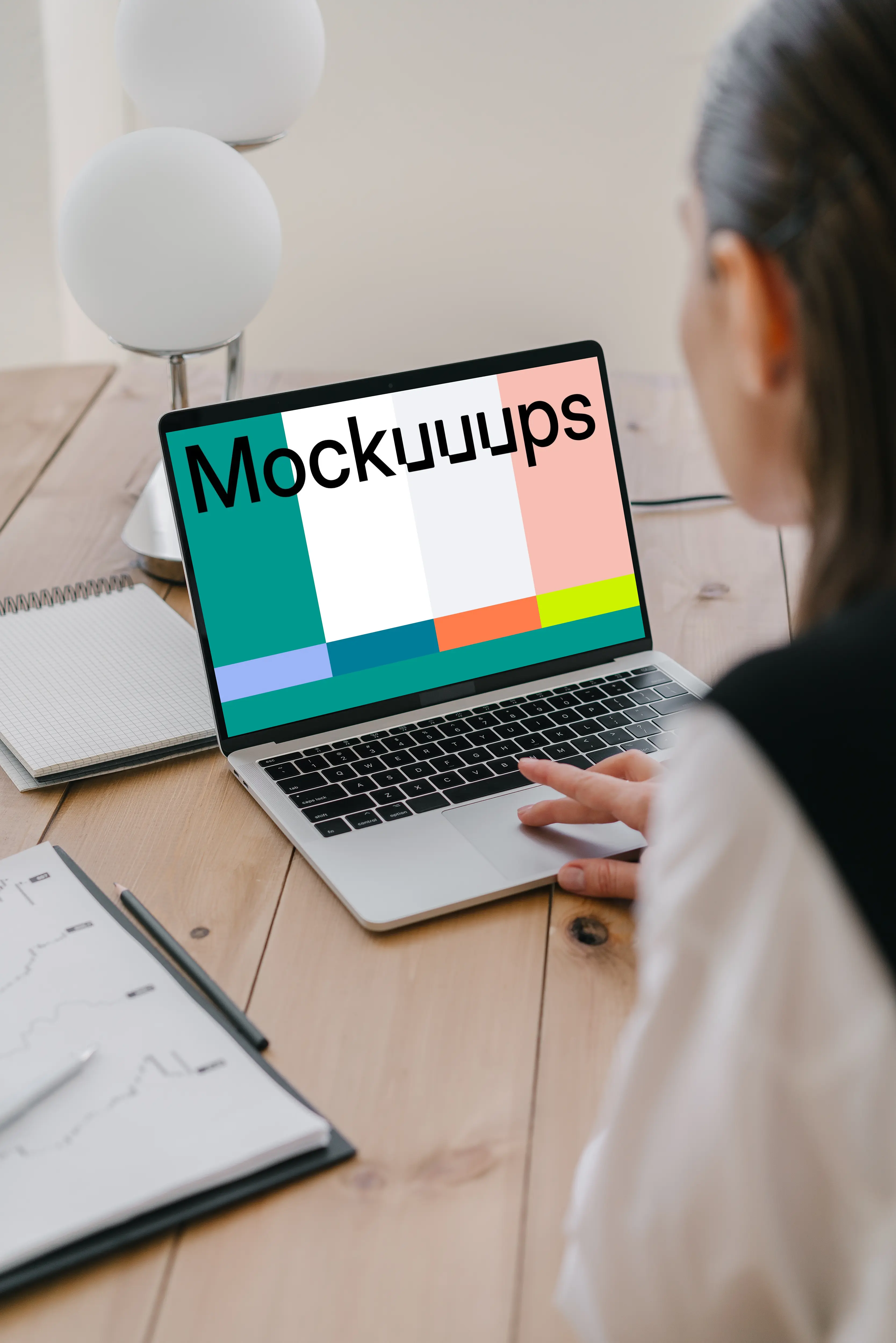 MacBook Air mockup in use by a lady with a notepad at the side