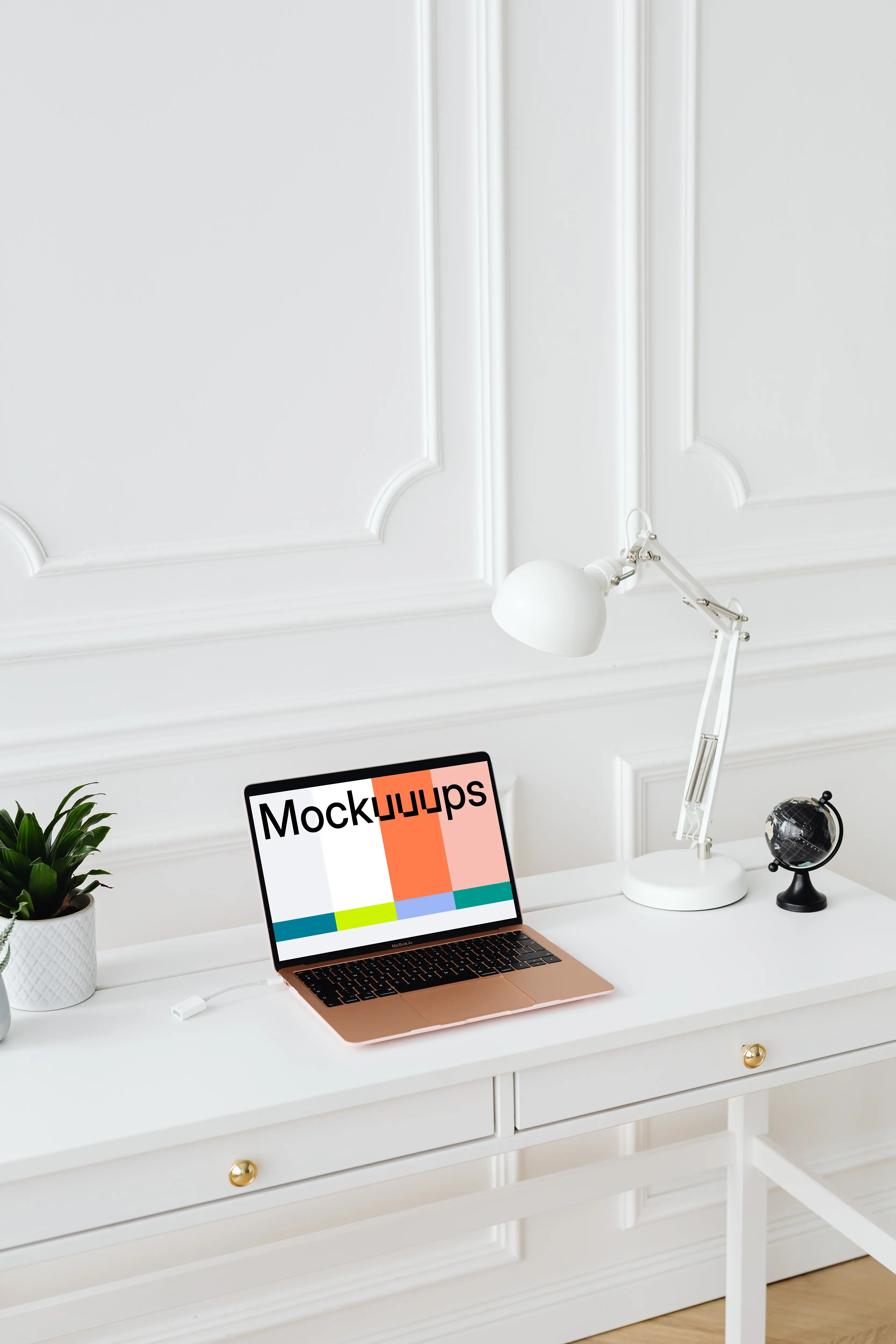 MacBook Air mockup on a white table beside a potted plant