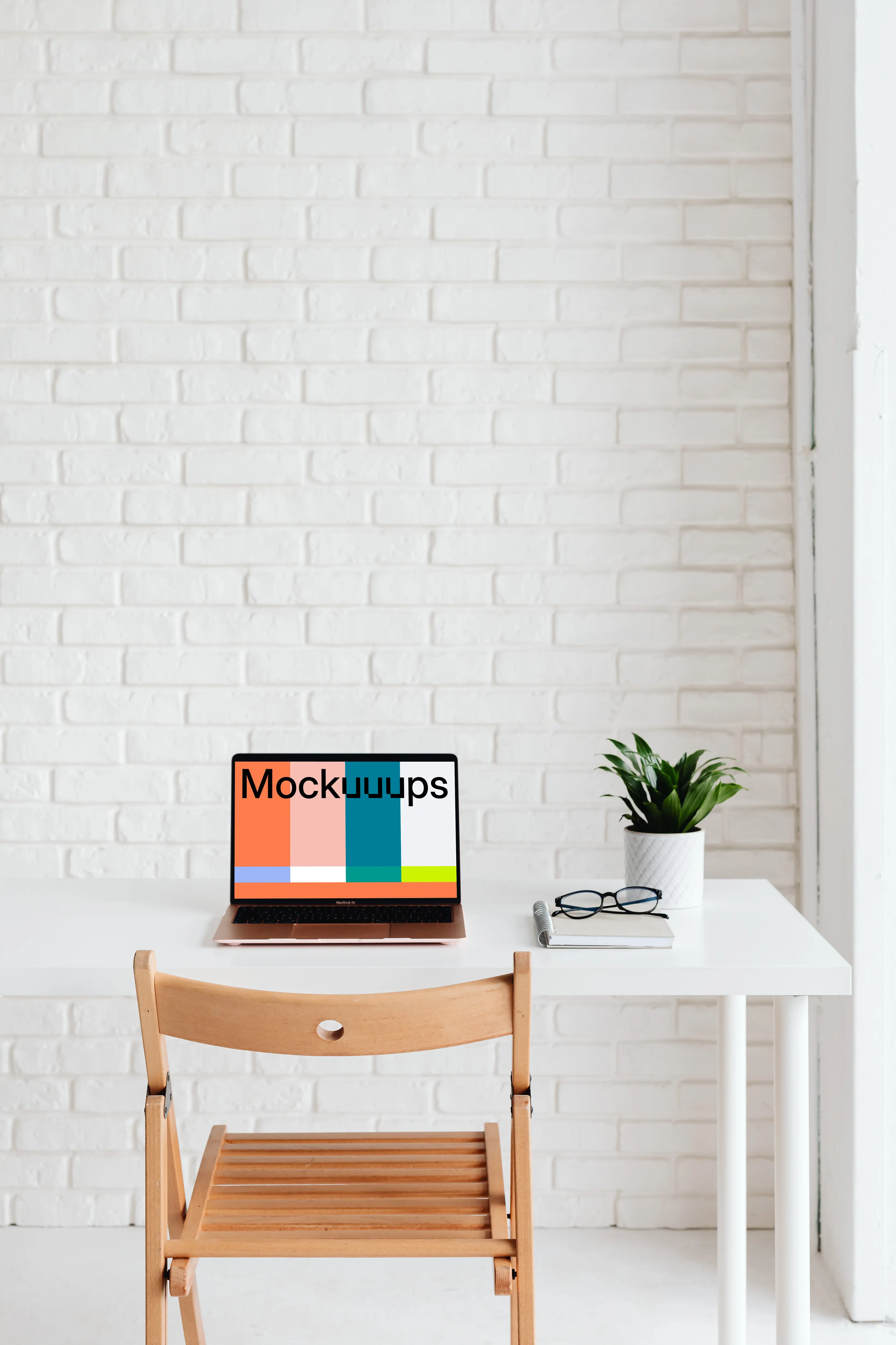 MacBook Air mockup with a notebook and pair of glasses at the side