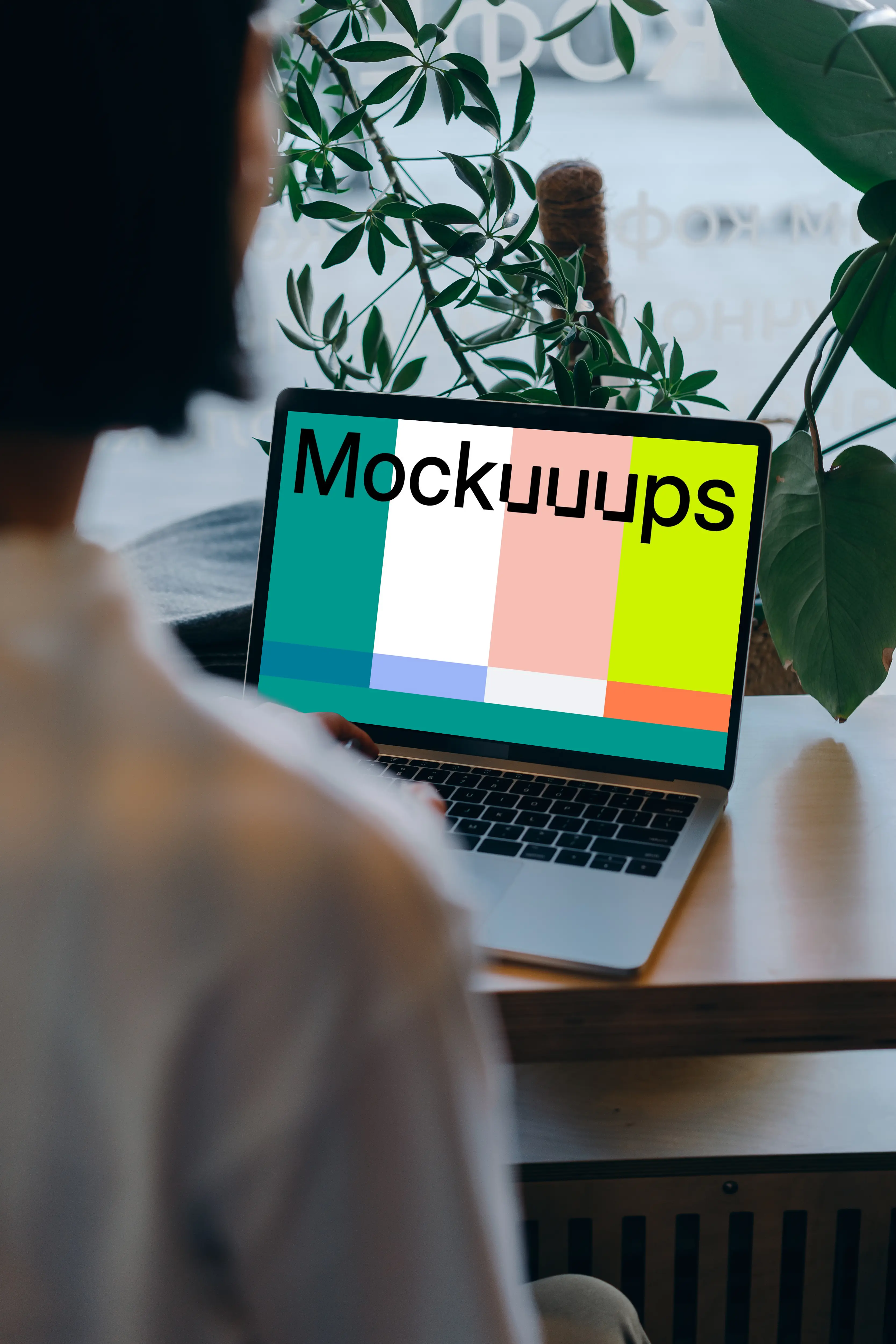 MacBook mockup in front of a user with plants in the background