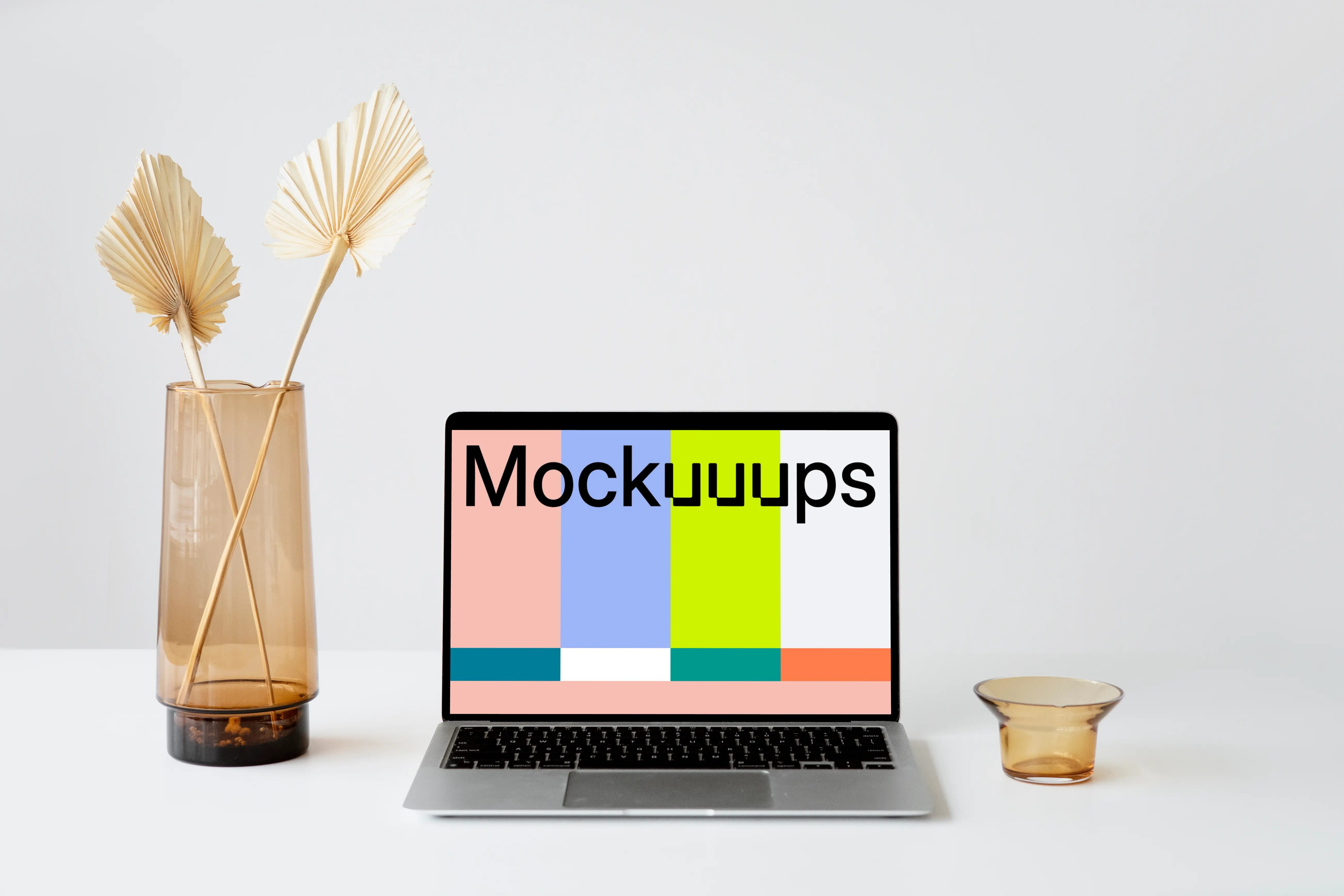 MacBook mockup on a white table with fancy flower vase at the side