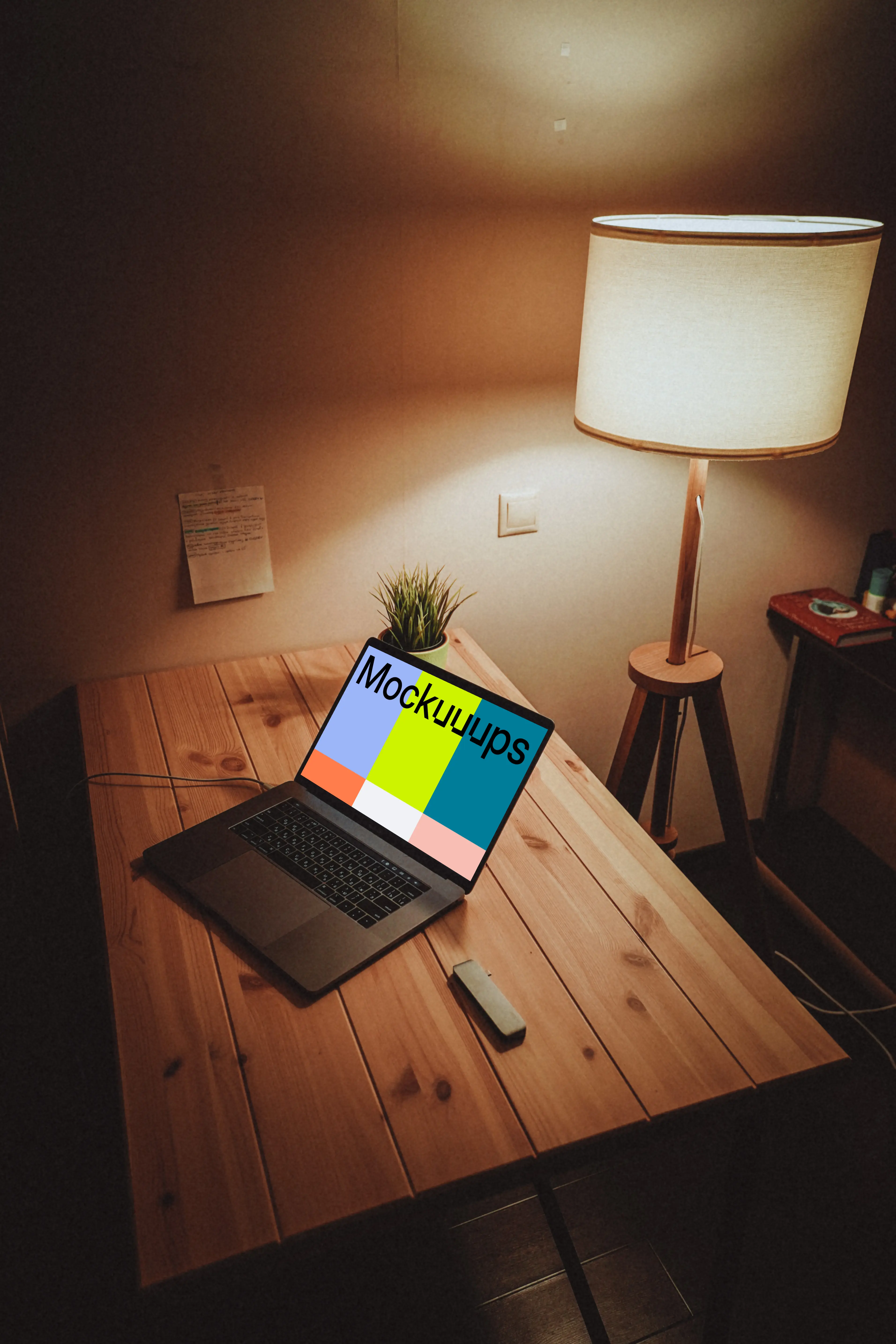 MacBook night mockup on a wooden table with a lamp by the side