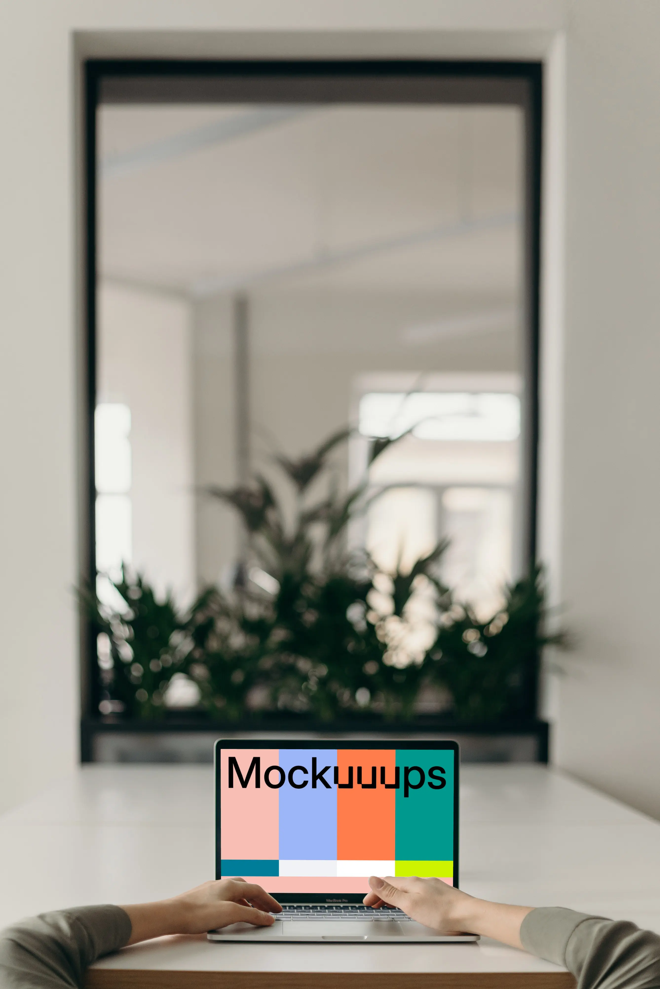 MacBook Pro mockup on a white table opposite an large mirror