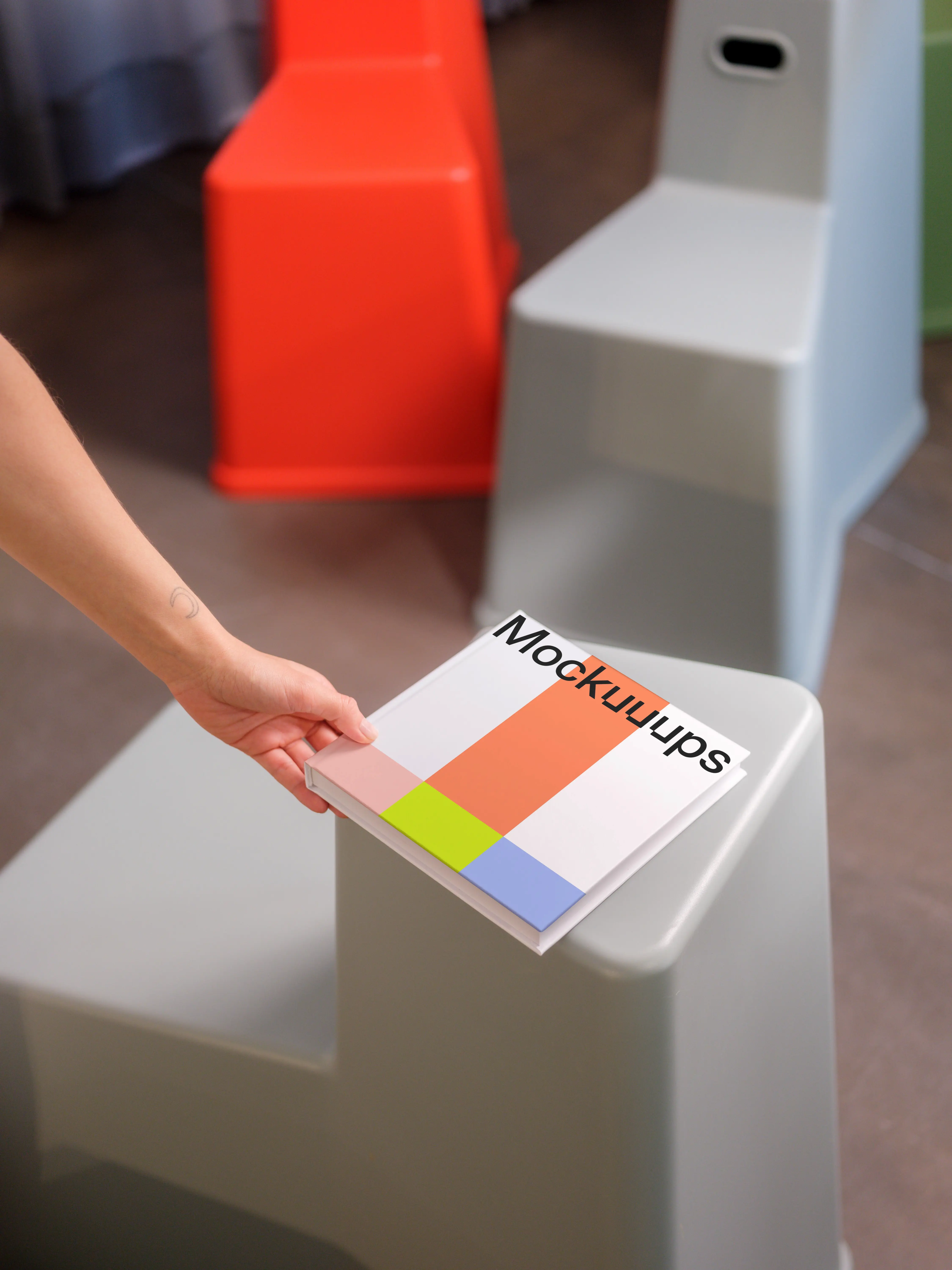 Mockup of square book on modern furniture