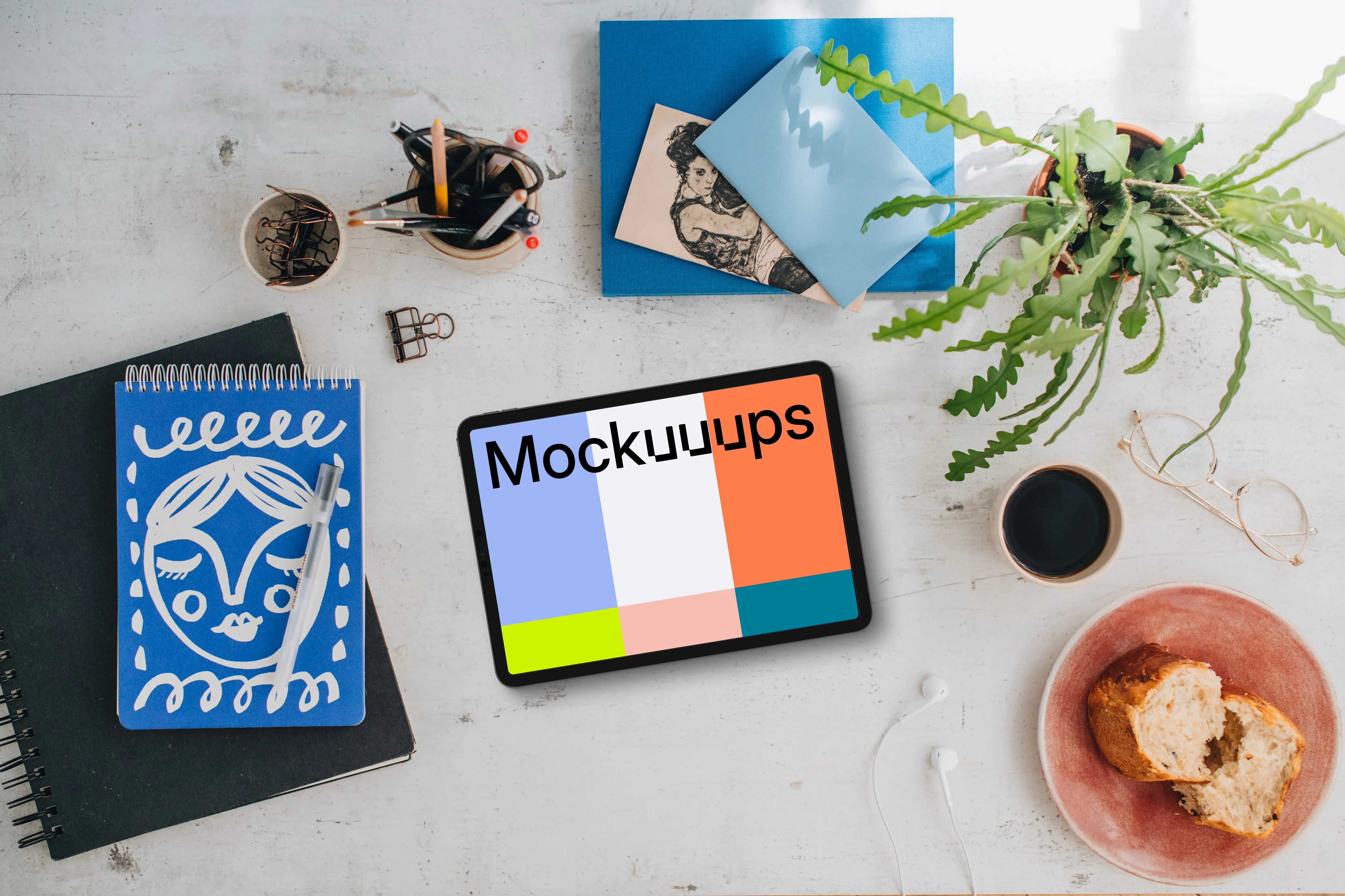 Mockup of tablet device with a plant and coffee on the side