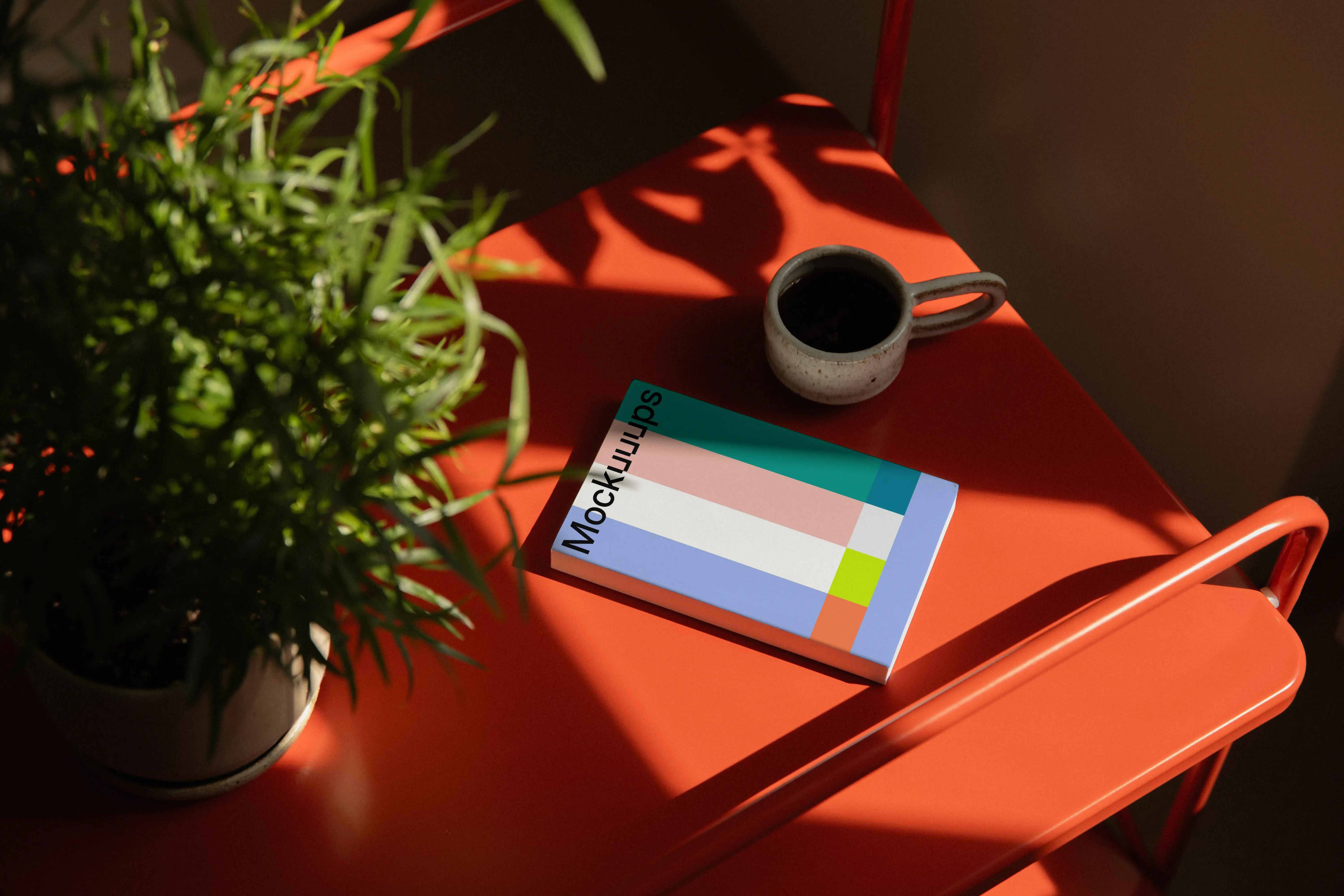 Paperback mockup on a bright red table with natural light