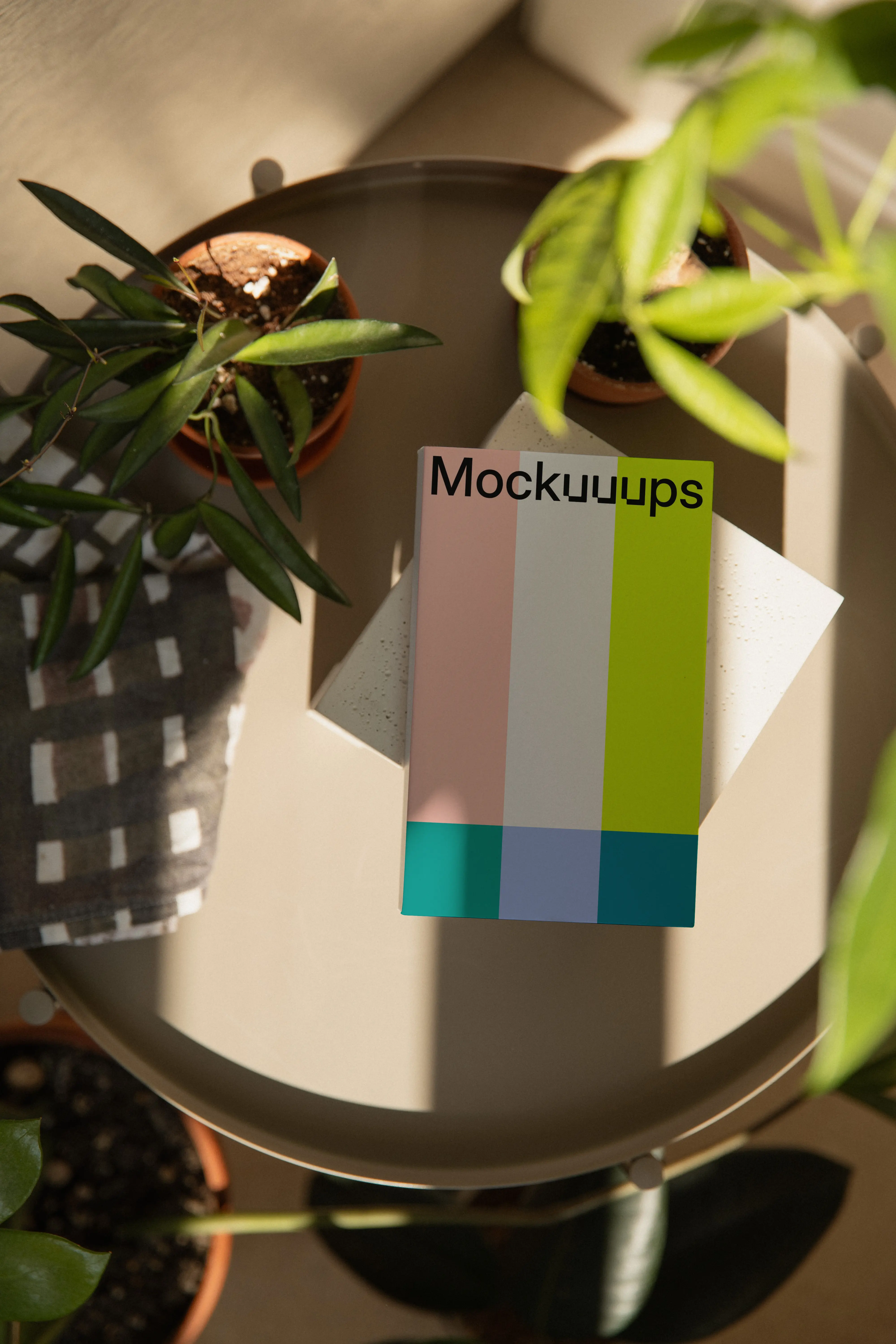 Paperback mockup on a round table with plants