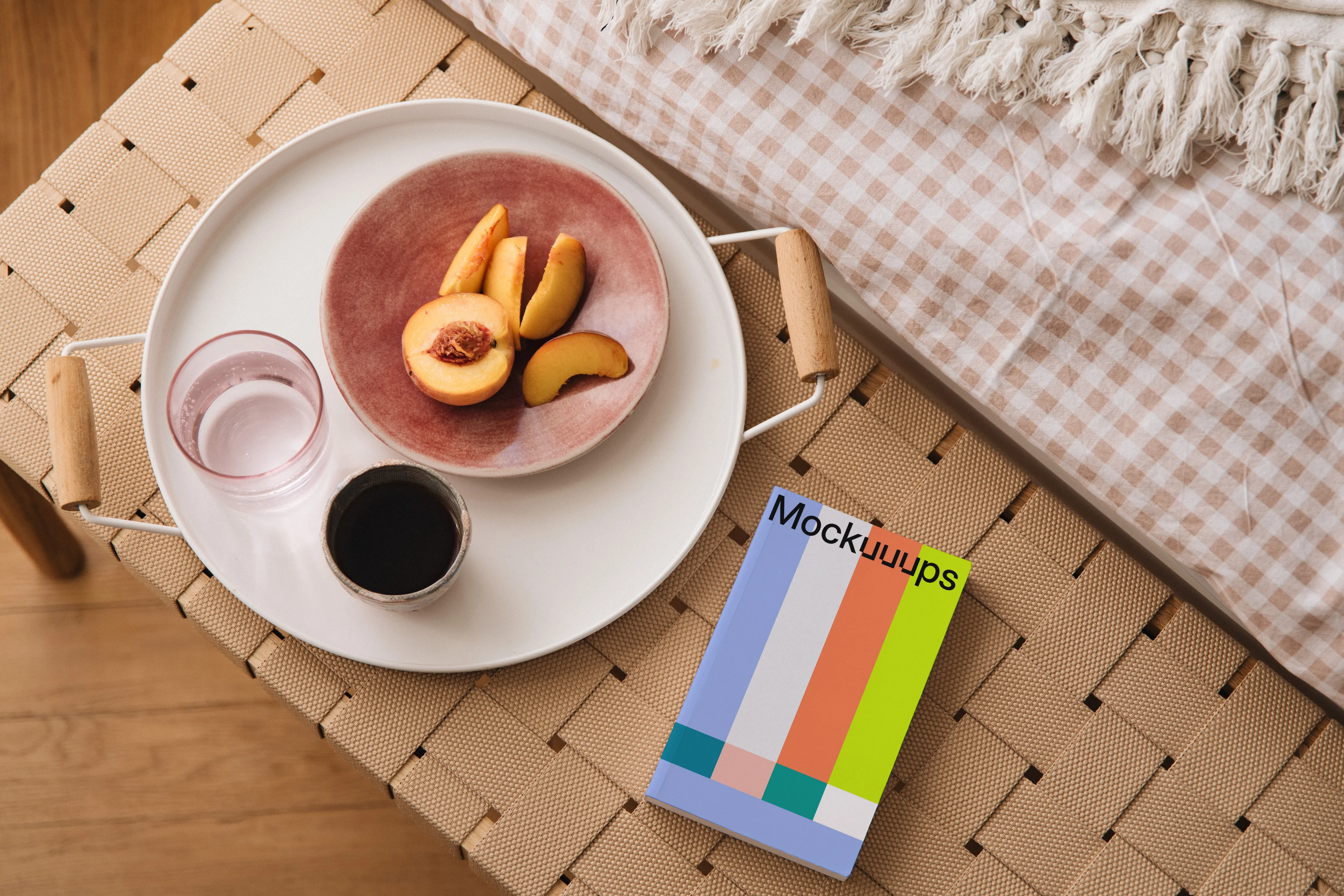Paperback mockup on a woven bench with a breakfast tray