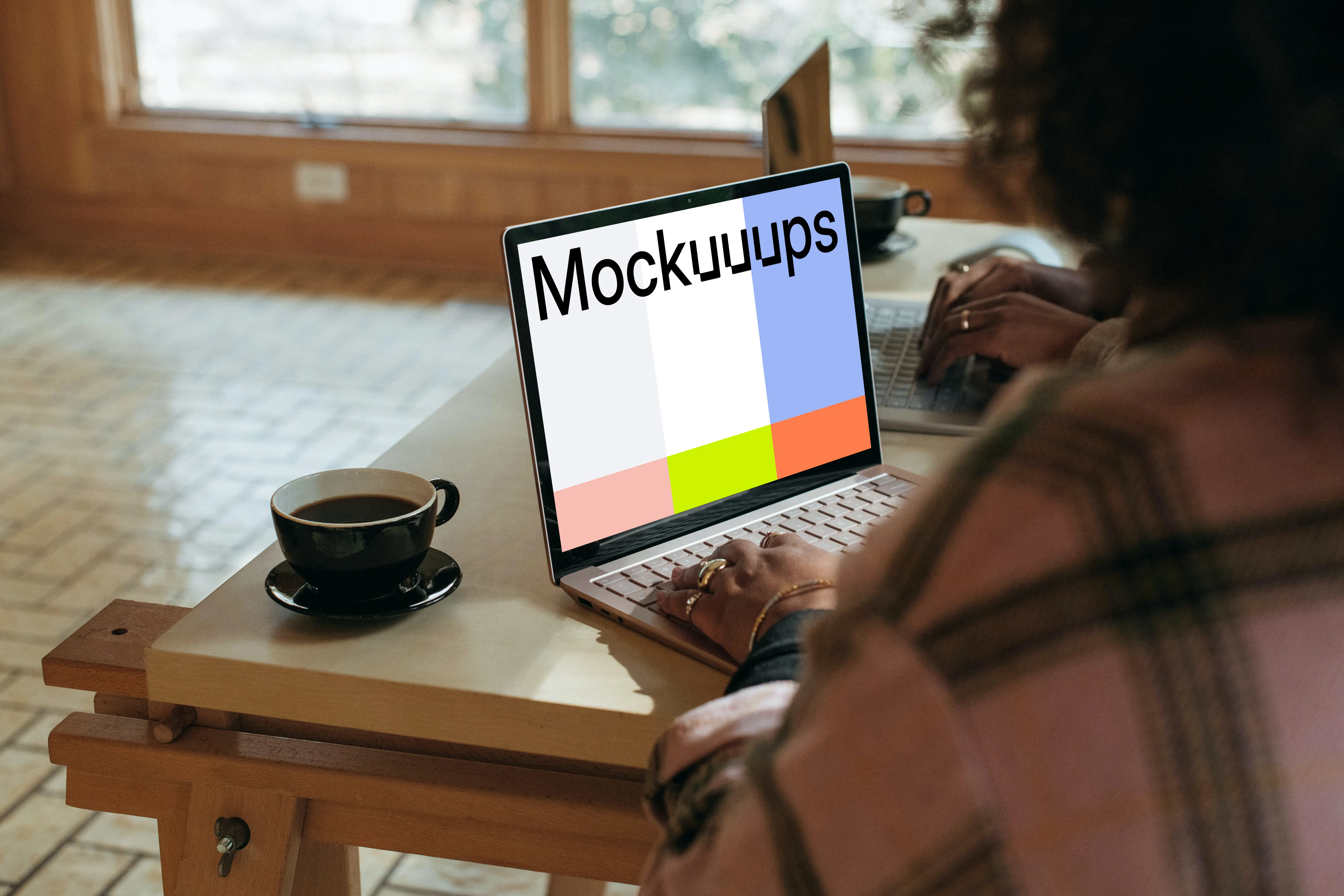 Sitting next to the colleague and working on the Microsoft Surface Laptop mockup