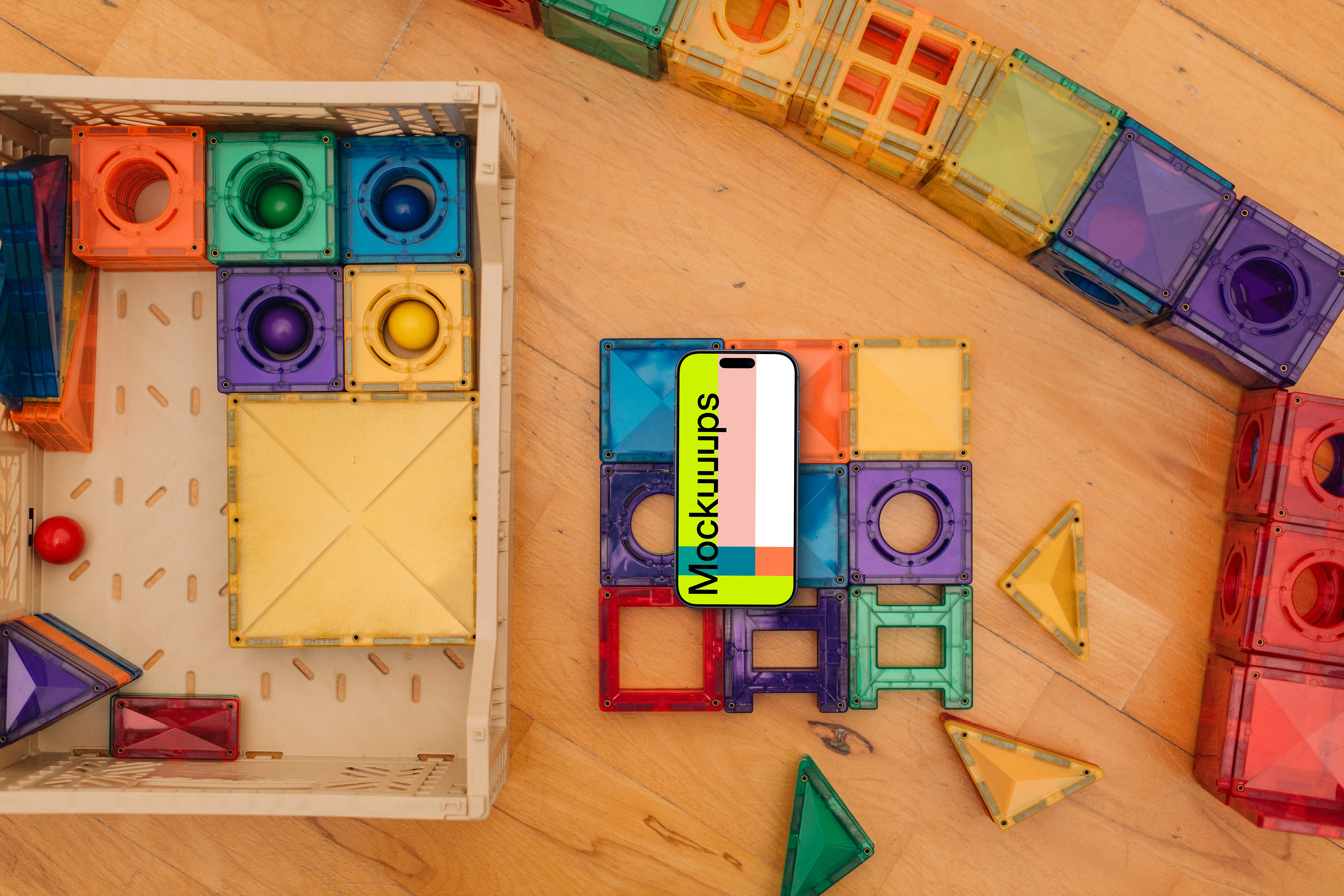 Smartphone mockup amidst colorful children's toys