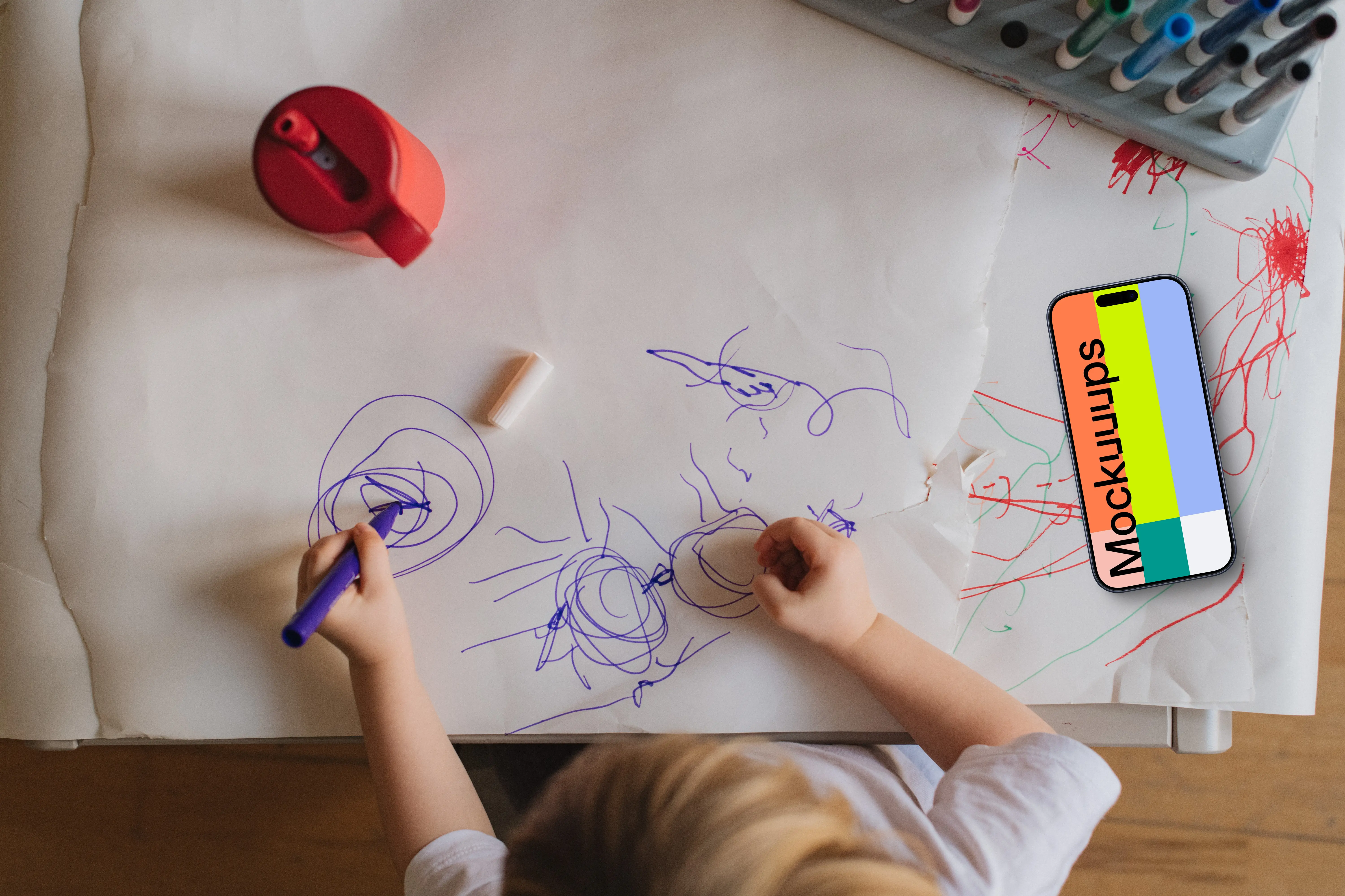 Smartphone mockup beside child's artwork
