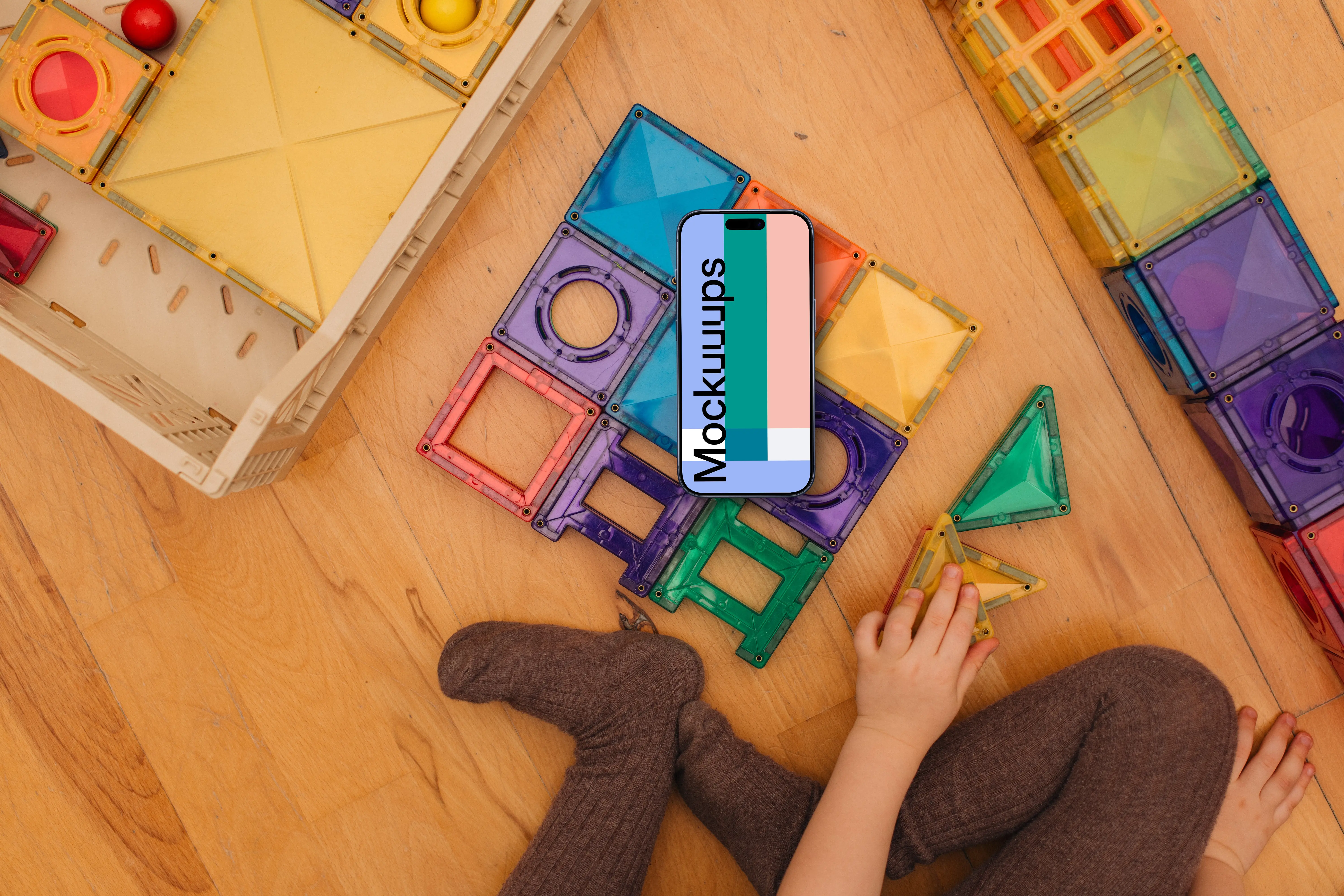 Smartphone mockup with colorful toy blocks and child's hands