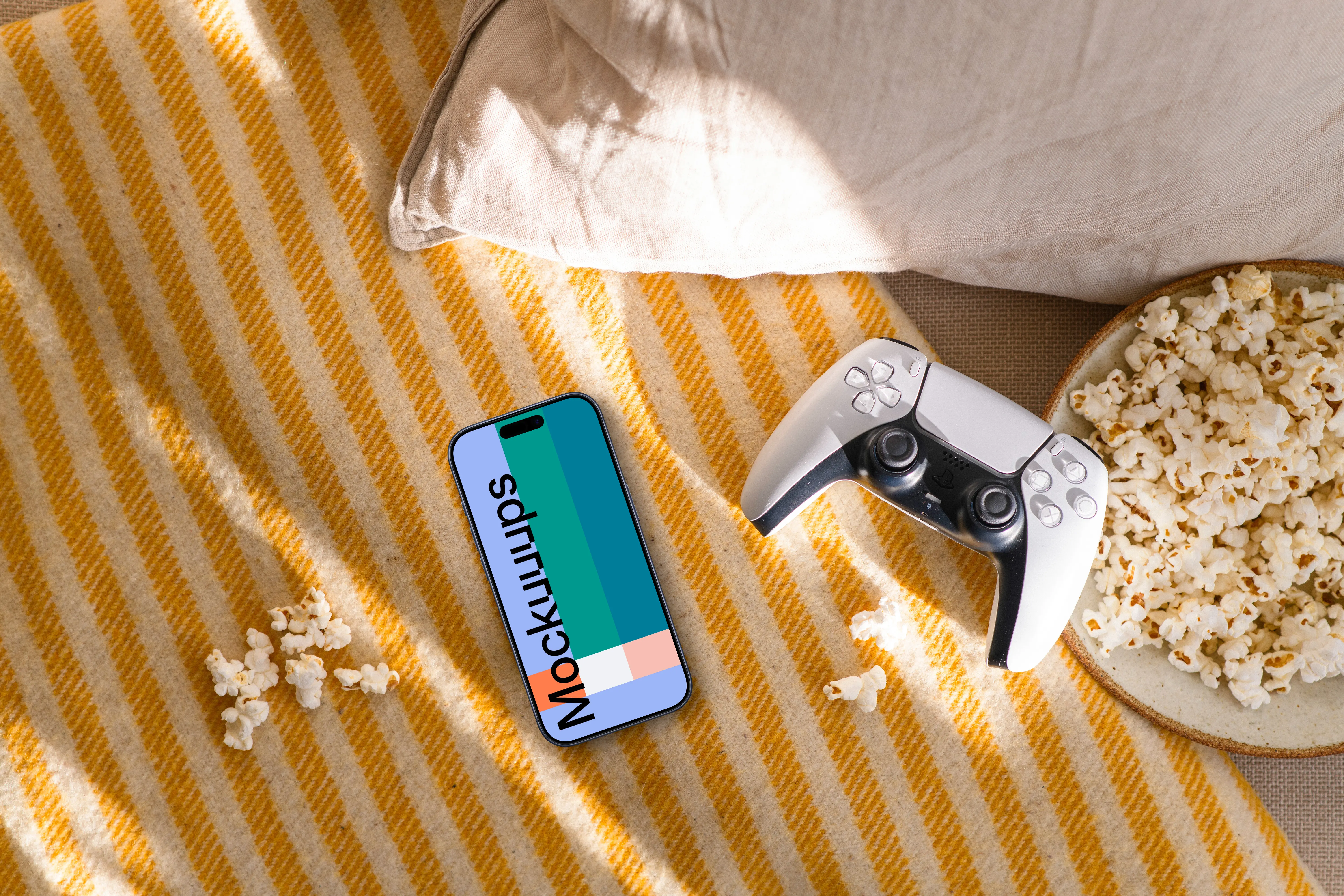 Smartphone mockup with gaming controller and snacks on cozy sofa